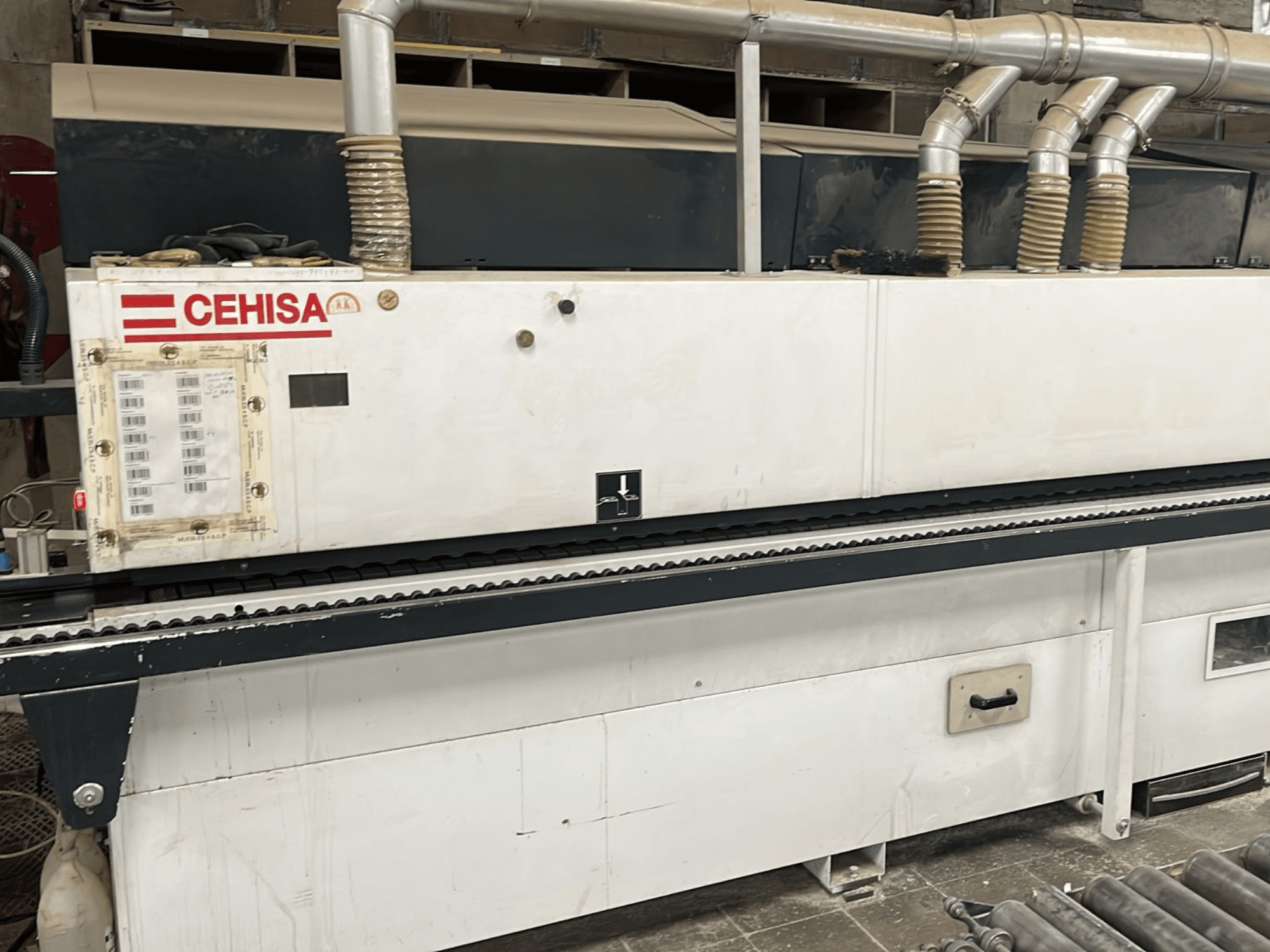 Kantenanleimmaschine „CEHISA PRO 12 CONCEPT“ in der Vorderansicht, mit Bedienfeld, Absaugrohren und Förderband.