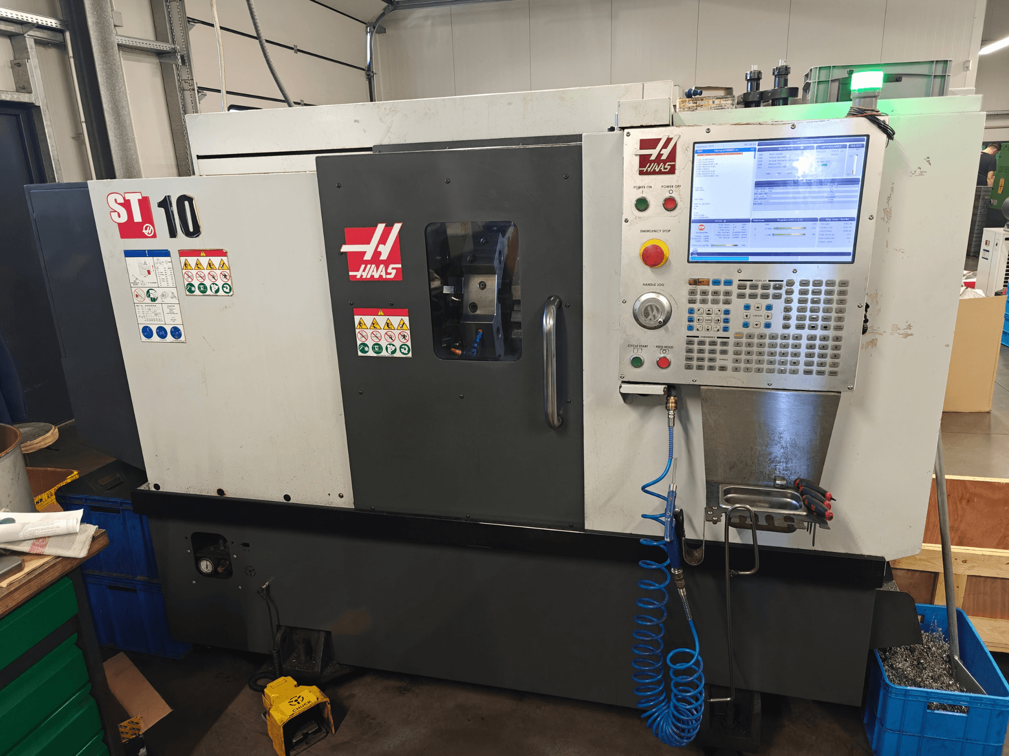 Haas ST-10 Horizontal-Drehmaschine, Vorderansicht, mit Blick auf das Bedienfeld, die Sicherheitsaufkleber und den Maschinenrahmen.