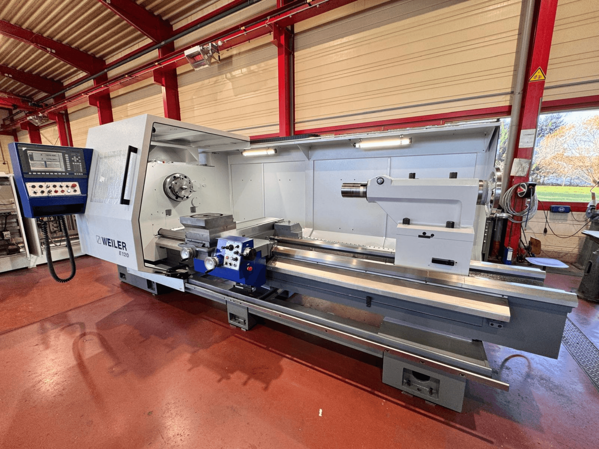 Die Weiler E120 Drehmaschine, Vorderansicht, verfügt über ein Bedienfeld, eine drehbare Spindel und ein Präzisionsbett mit Linearführungen.