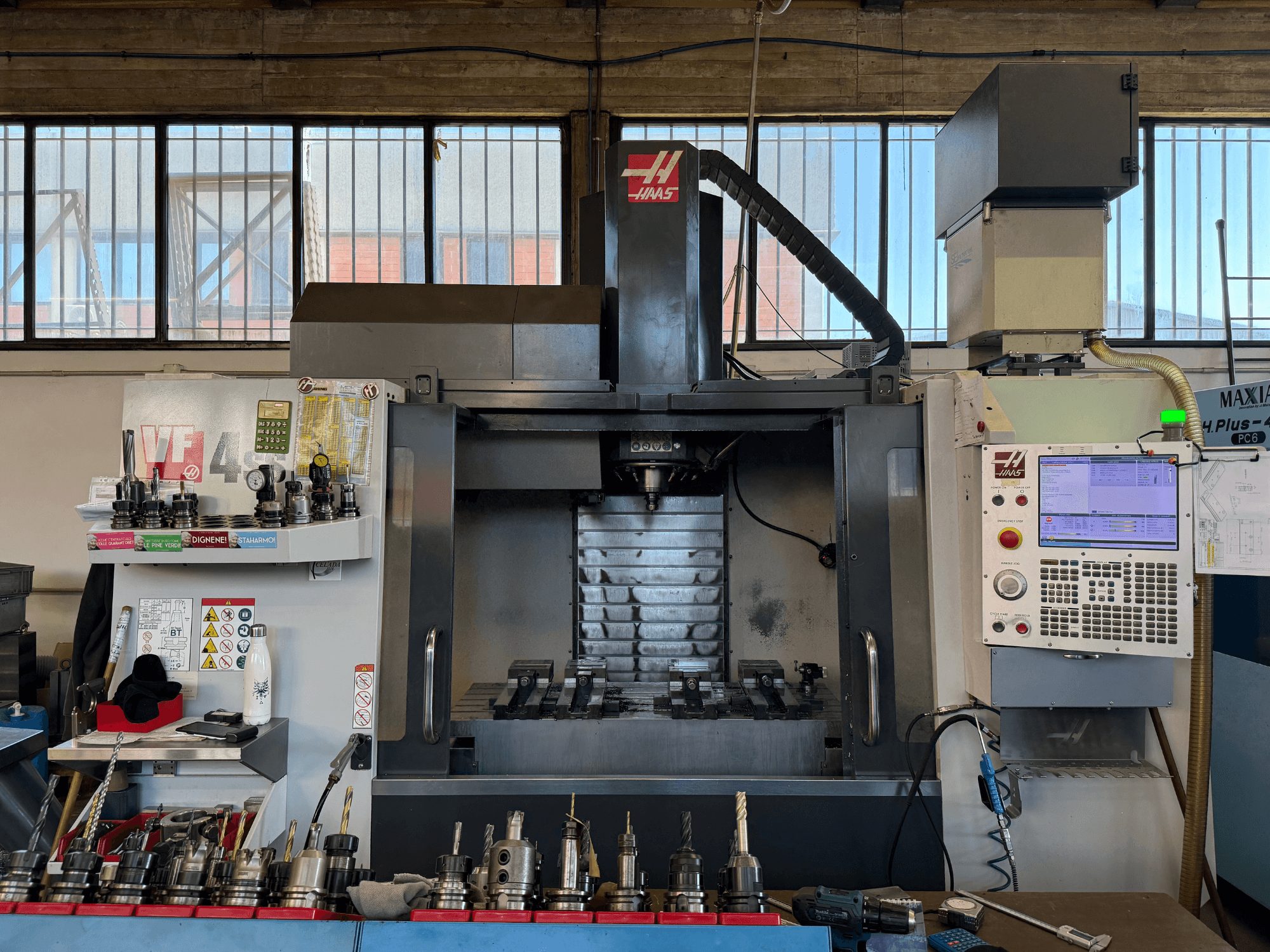 Vertikales Bearbeitungszentrum HAAS VF-4SS, Vorderansicht, mit Bedienfeld, Werkzeughaltern und sichtbarem Spindelbereich.