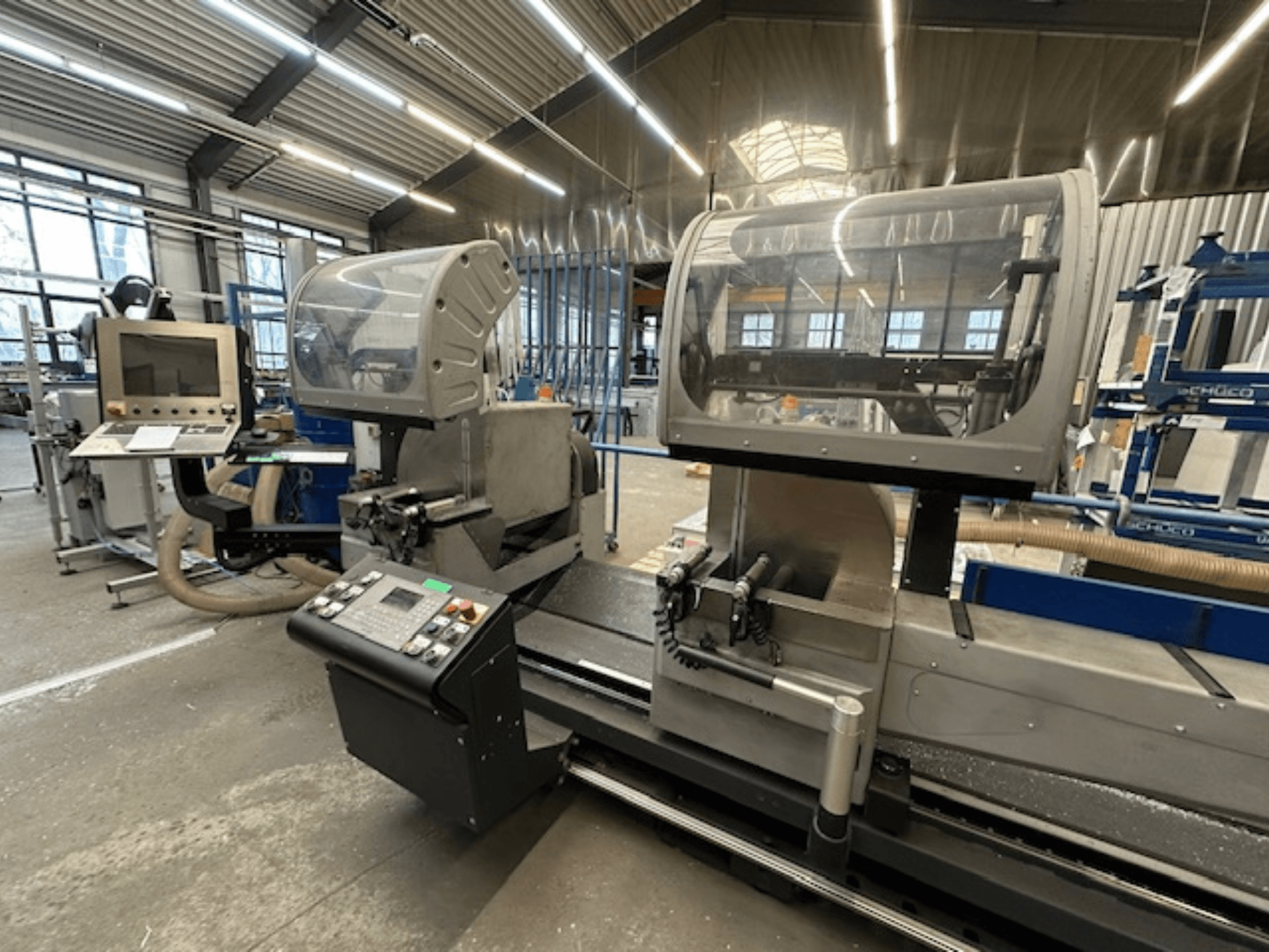 SCHÜCO PDG E CUT Metallkreissäge, Vorderansicht, mit Bedienfeld, Schutzabdeckungen und Schnittbereich in einer Werkstattumgebung.