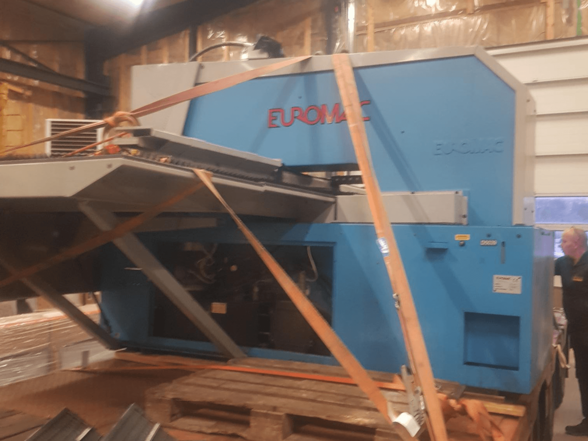 CNC-Stanzmaschine Euromac ZX INDEX in der Seitenansicht, mit Riemen gesichert, mit blauer Metalloberfläche.