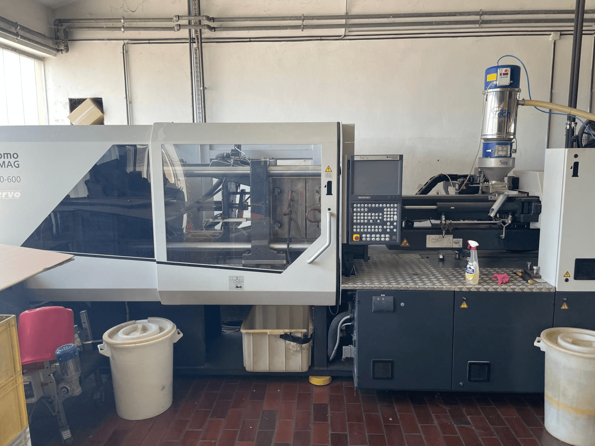 Frontansicht der hydraulischen Spritzgießmaschine SUMITOMO SHI DEMAG Systec 160/520-600 mit Bedienpult und Vorschubeinheit.