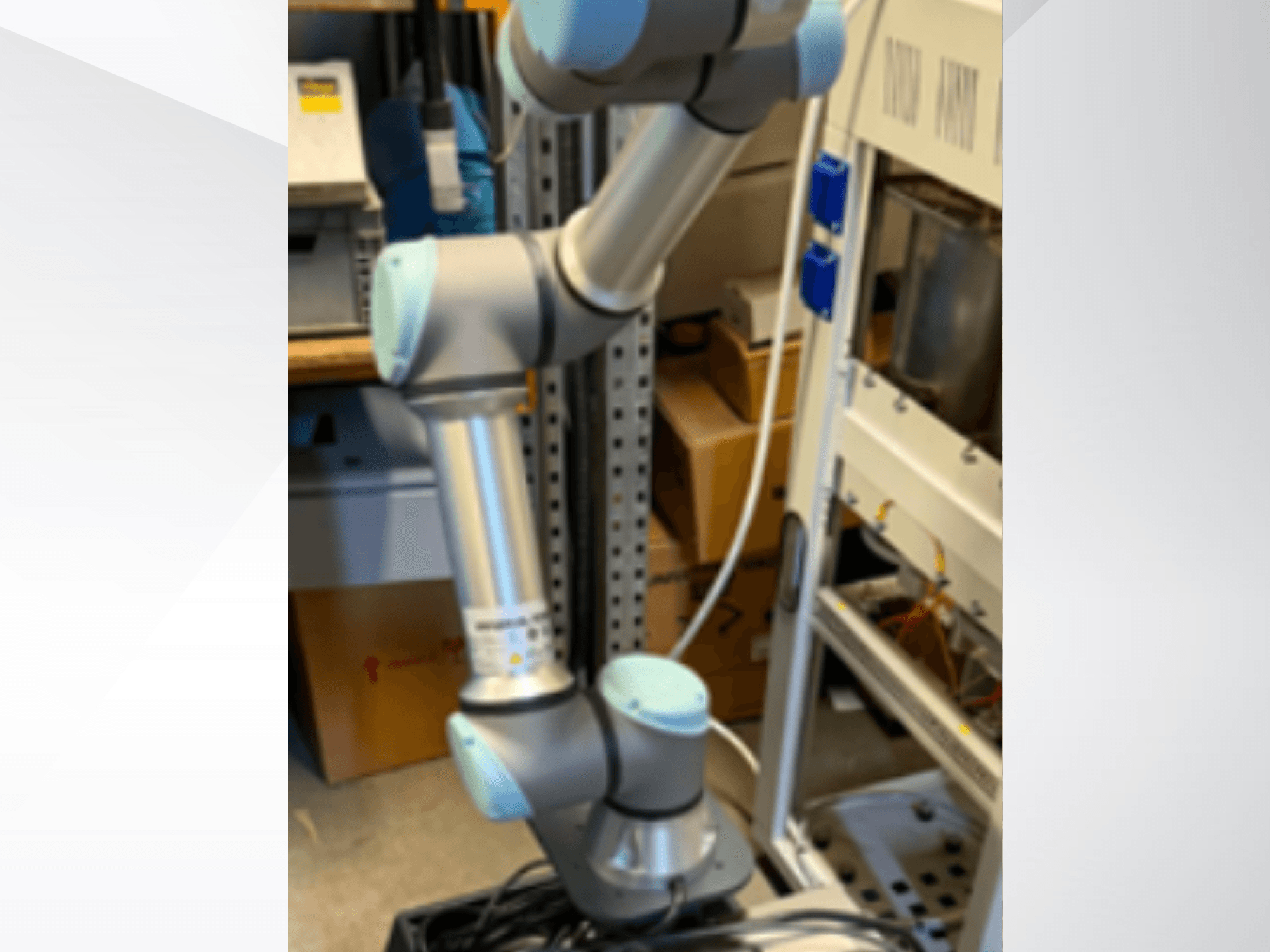 Der Roboterarm UR5e von Universal Robots in Seitenansicht, mit sichtbaren Gelenken, leichter Bauweise und Steuerkabeln.