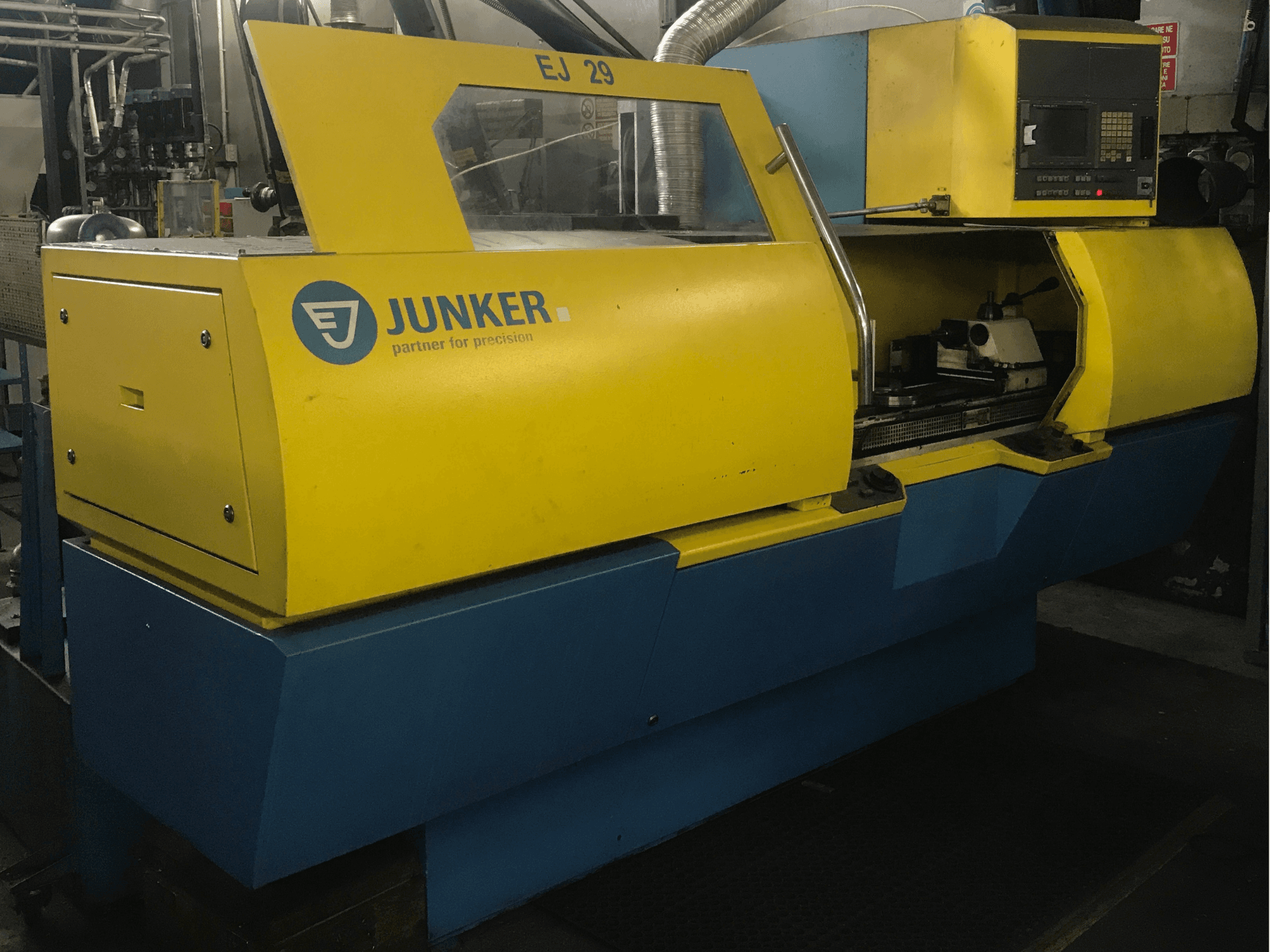 JUNKER Schleifmaschine EJ 29, Vorderansicht, mit gelbem und blauem Gehäuse, Bedienfeld und sichtbaren internen Komponenten.