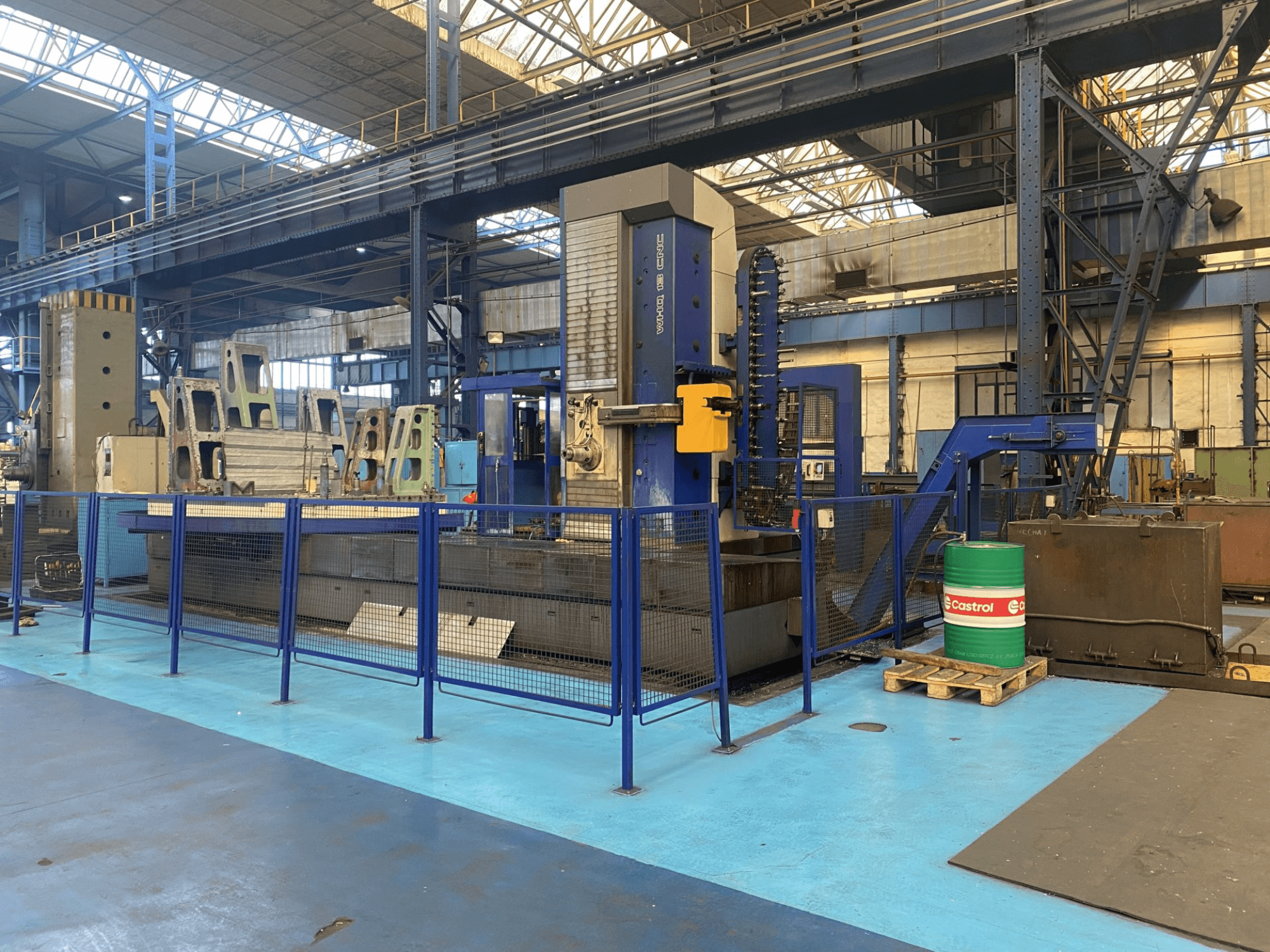 TOS WHQ 13 CNC-Bohrmaschine in einer Werkstatt, Vorderansicht, mit blauem Rahmen und umlaufendem Schutzzaun.