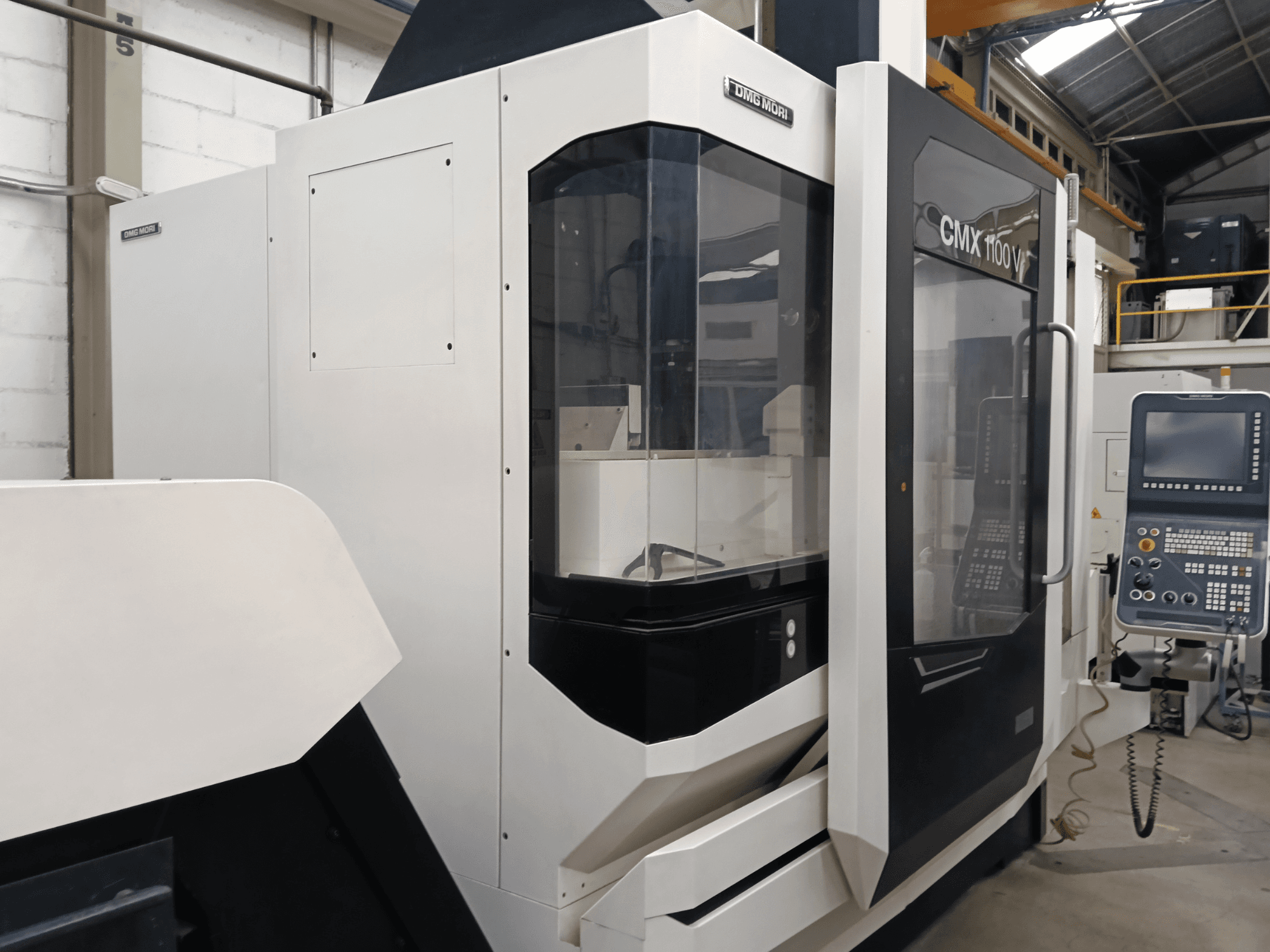 Vertikales Bearbeitungszentrum DMG MORI CMX 1100 V, Vorderansicht, mit Bedienfeld und Glasabdeckung.