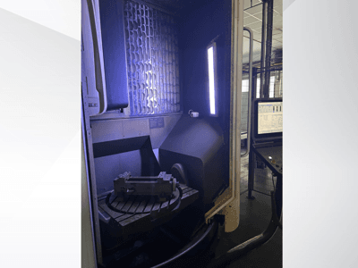 Vertikales Bearbeitungszentrum DMG MORI DMU 65 MonoBlock, Vorderansicht mit Drehtisch, Werkstück und Bedienfeld.