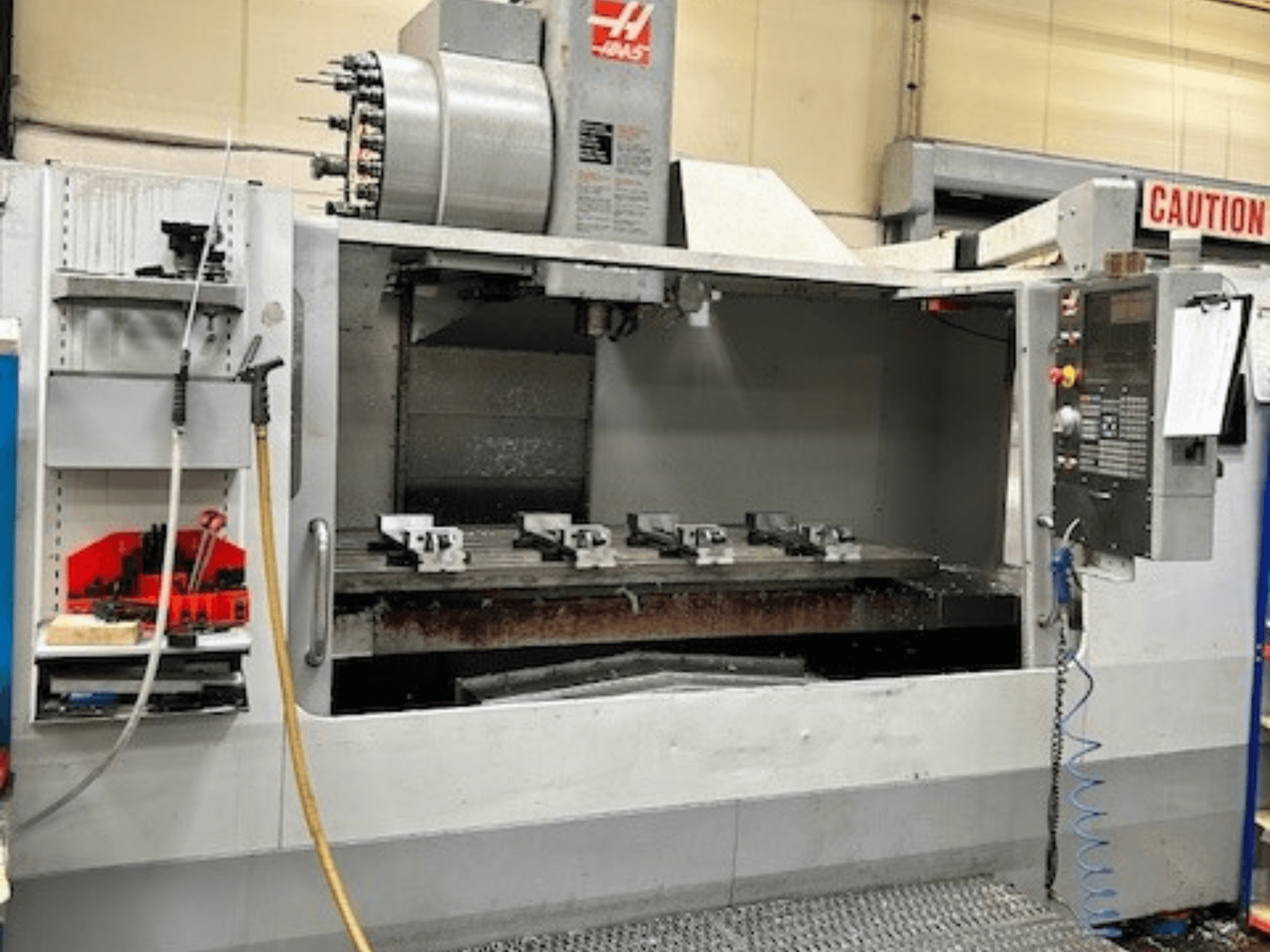 HAAS VF-9/40HE Vertikal-Bearbeitungszentrum, Vorderansicht, mit Werkzeughalter und Zubehör an der Seite.