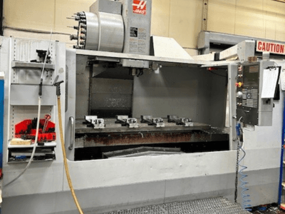 HAAS VF-9/40HE Vertikal-Bearbeitungszentrum, Vorderansicht, mit Werkzeughalter und Zubehör an der Seite.