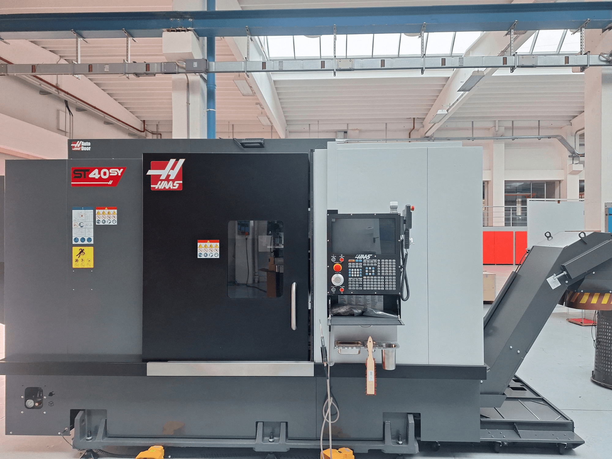 Horizontaldrehmaschine Haas ST-40SY in Seitenansicht, mit Bedienfeld und Sicherheitsaufklebern.