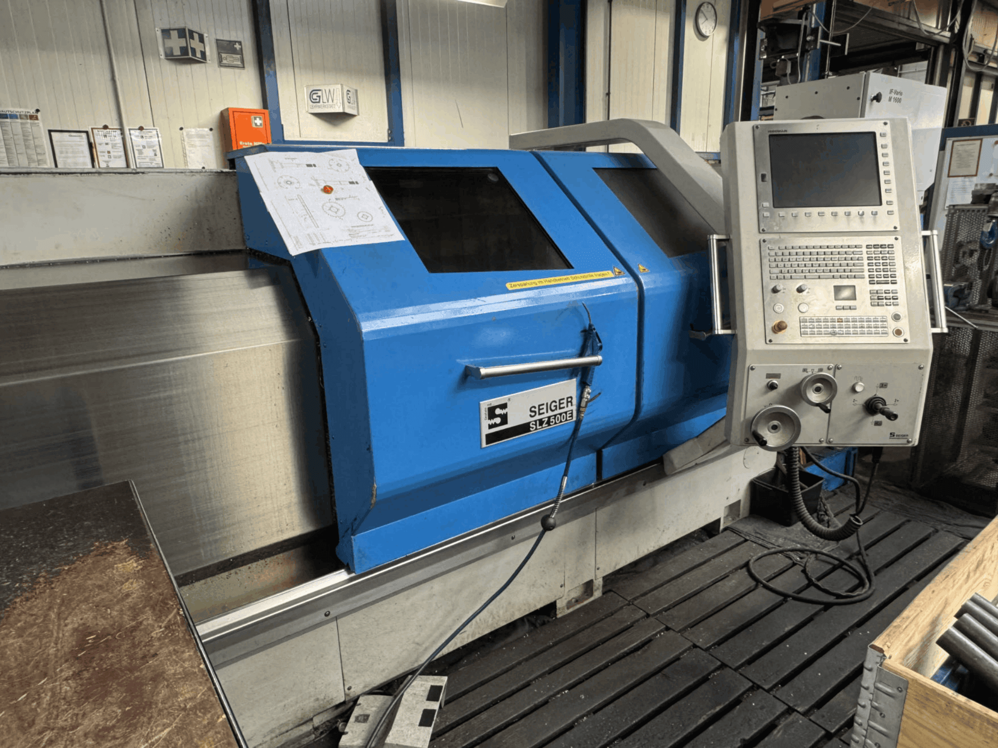 Vorderansicht der horizontalen Drehmaschine SEIGER SLZ 500E mit Bedienfeld, blauer Außenverkleidung und einer angezeigten Konstruktionszeichnung.