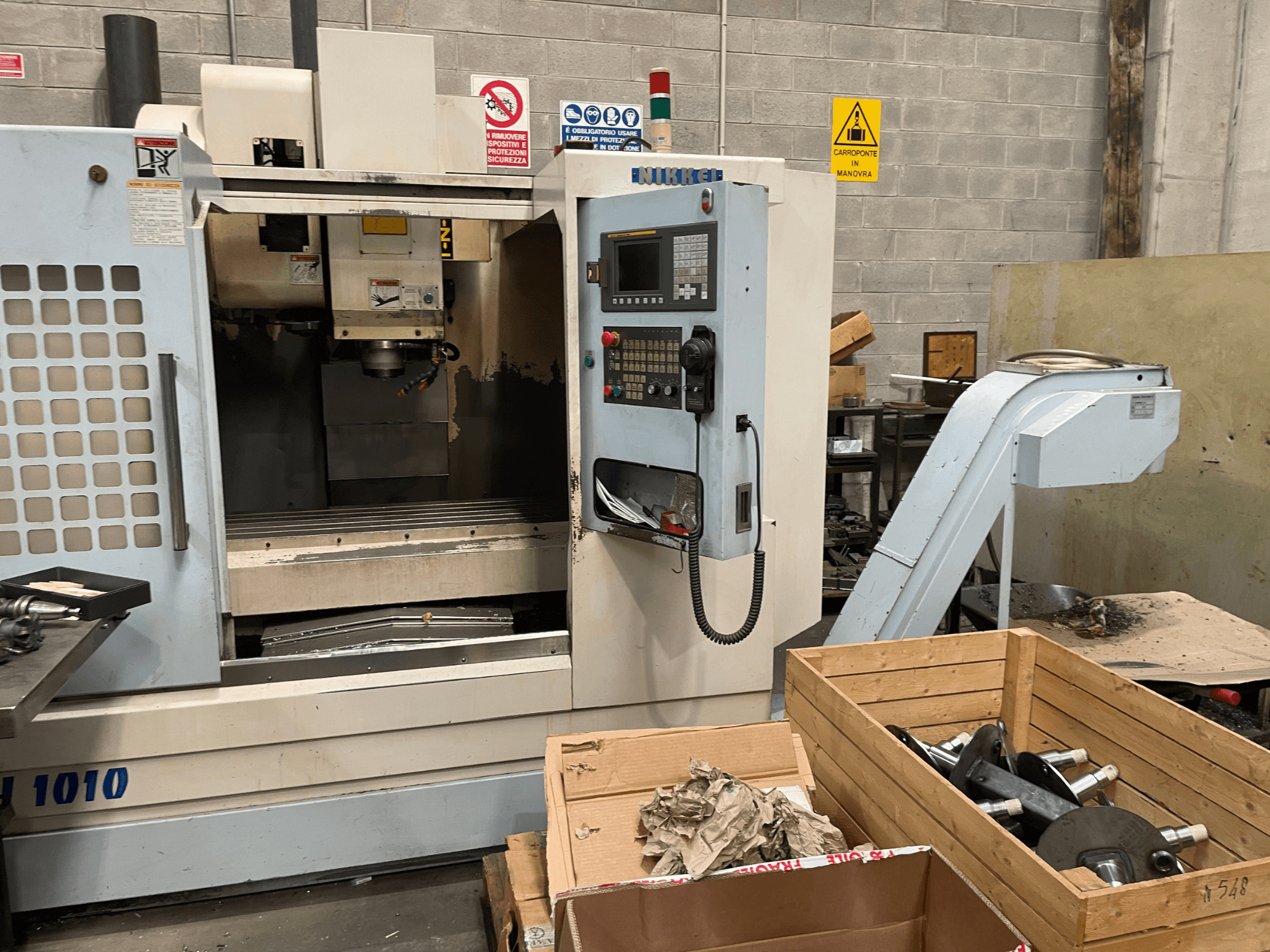 Vertikales Bearbeitungszentrum von Other, Modell VH-1010, von vorne gesehen, mit sichtbaren Bedienelementen und Boxen in der Nähe.