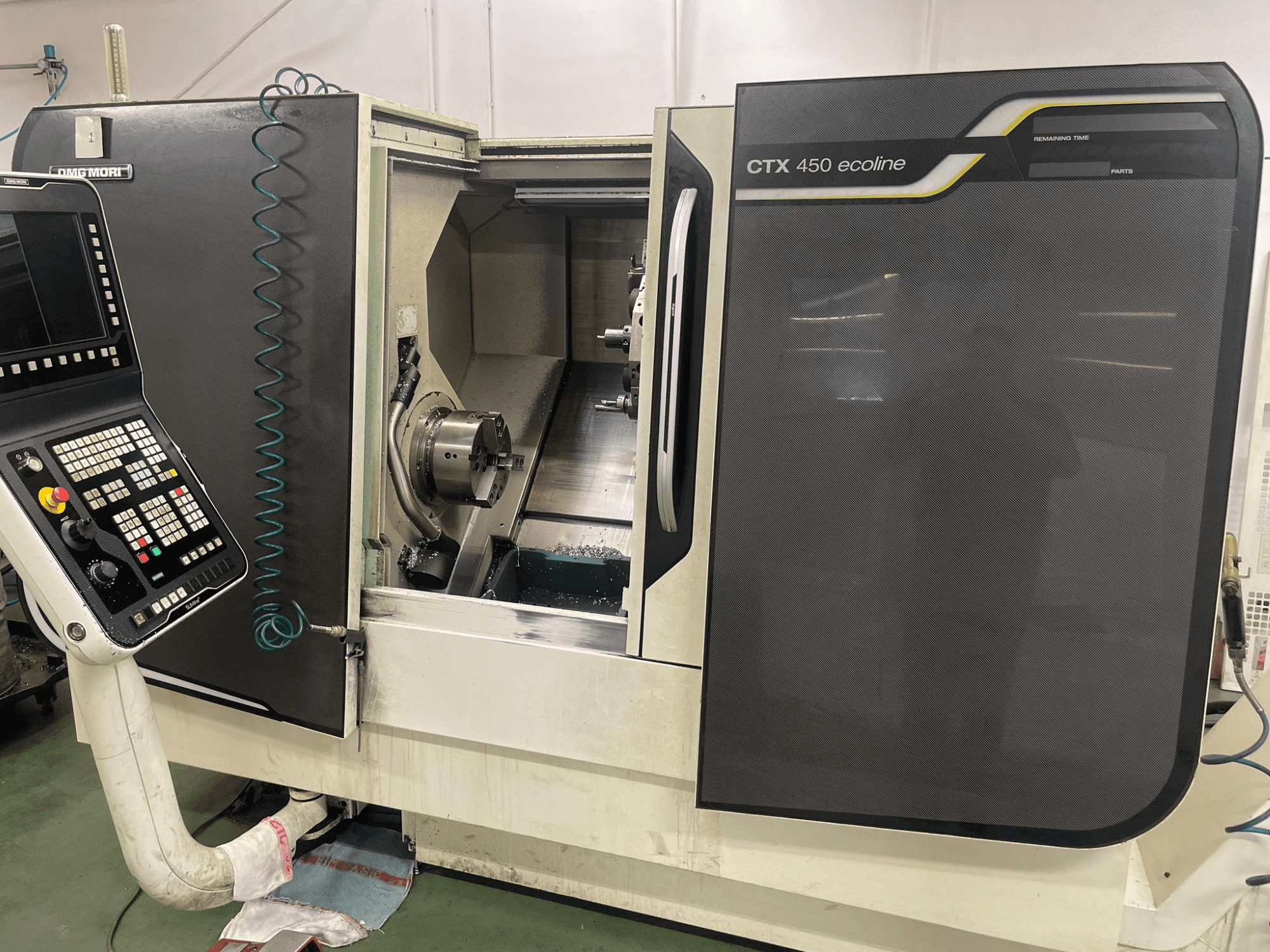 DMG MORI CTX 450 ecoline CNC-Maschine in der Seitenansicht, mit Bedienfeld, Spannfutter und Bearbeitungsbereich.
