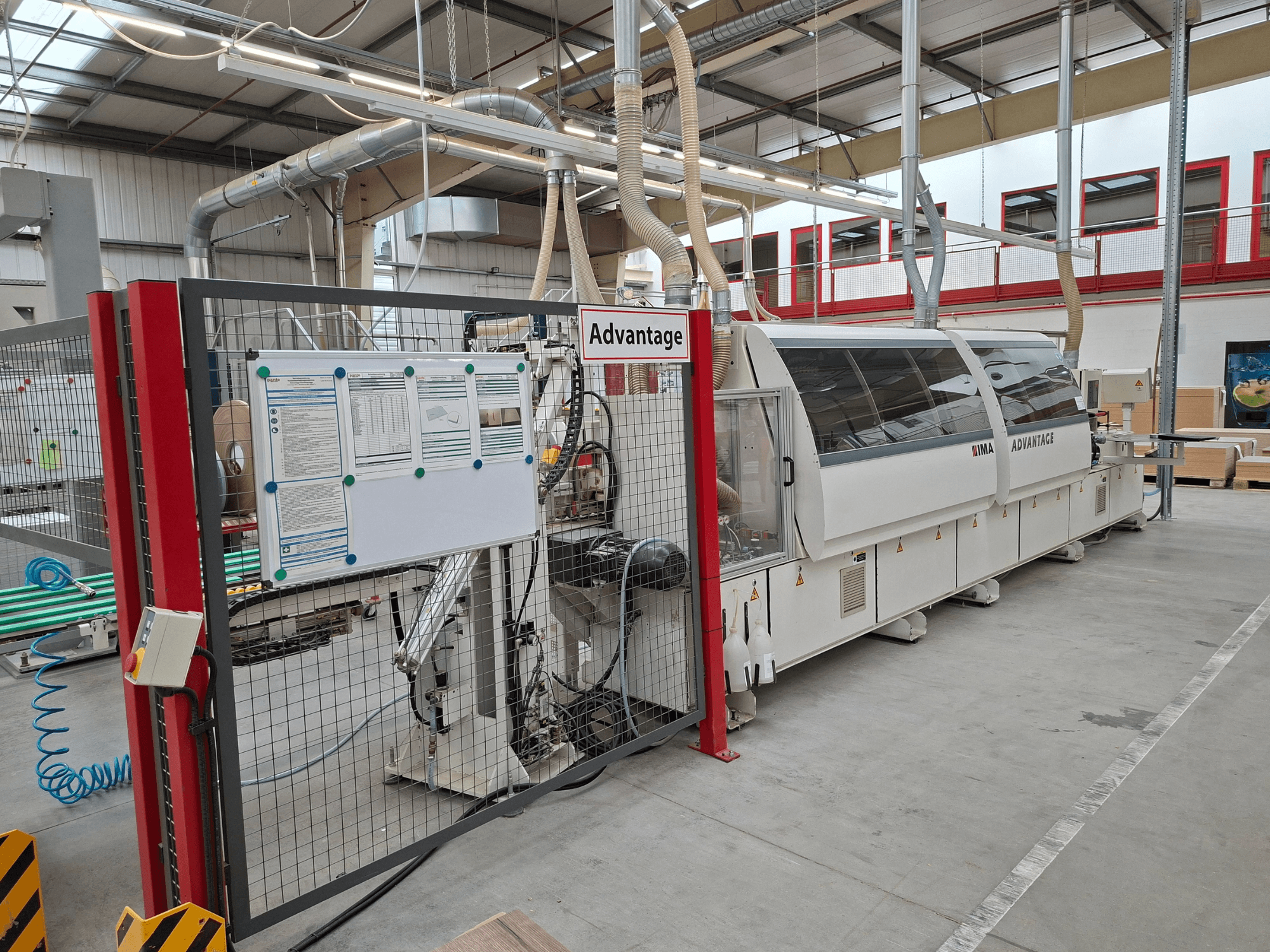 IMA Advantage 600 Kantenanleimmaschine von vorne gesehen, mit Sicherheitszaun und Bedienfeld in einer Werkstattumgebung.