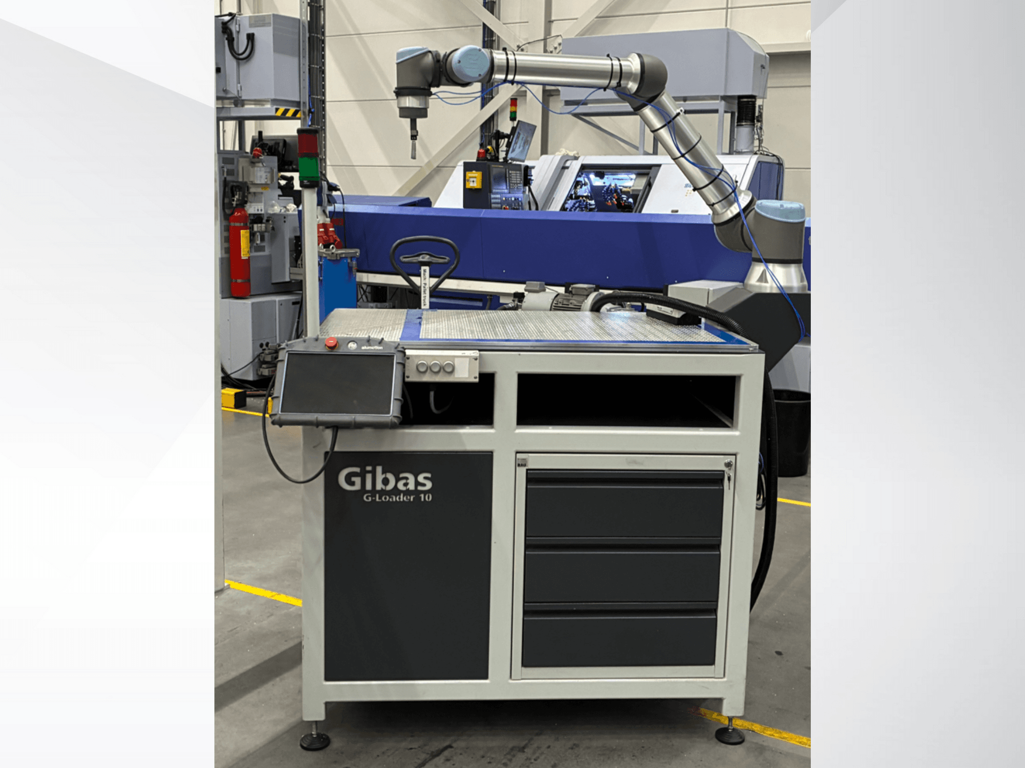 Gibas G-Loader 10 mit Roboterarm, Vorderansicht; mit Touchscreen-Steuerung und Schubladenlager in Industrieumgebung.