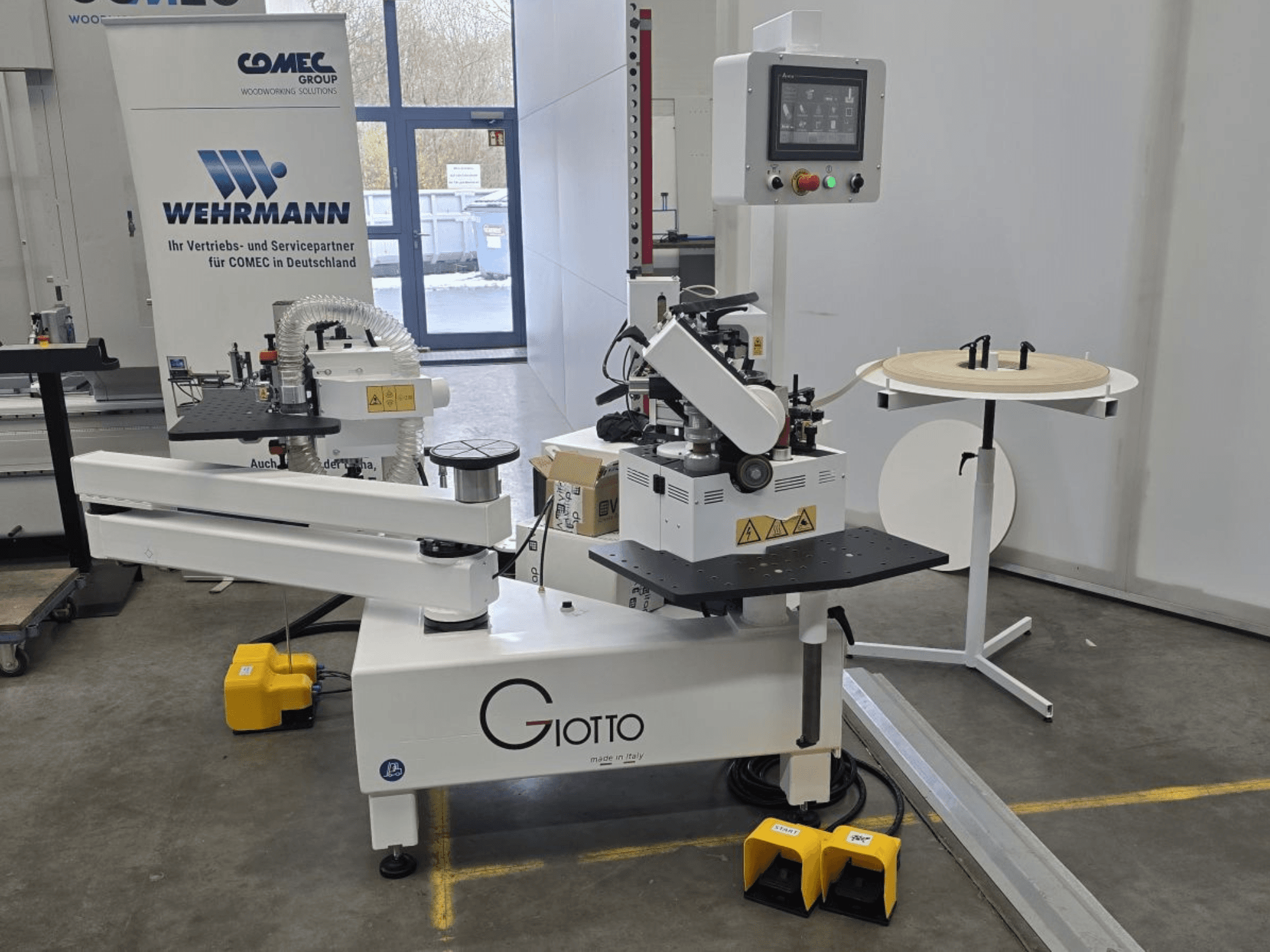 Giotto Holzbearbeitungsmaschine mit Bedienfeld, Seitenansicht, mit Fußpedalen und drehbarer Arbeitsfläche.