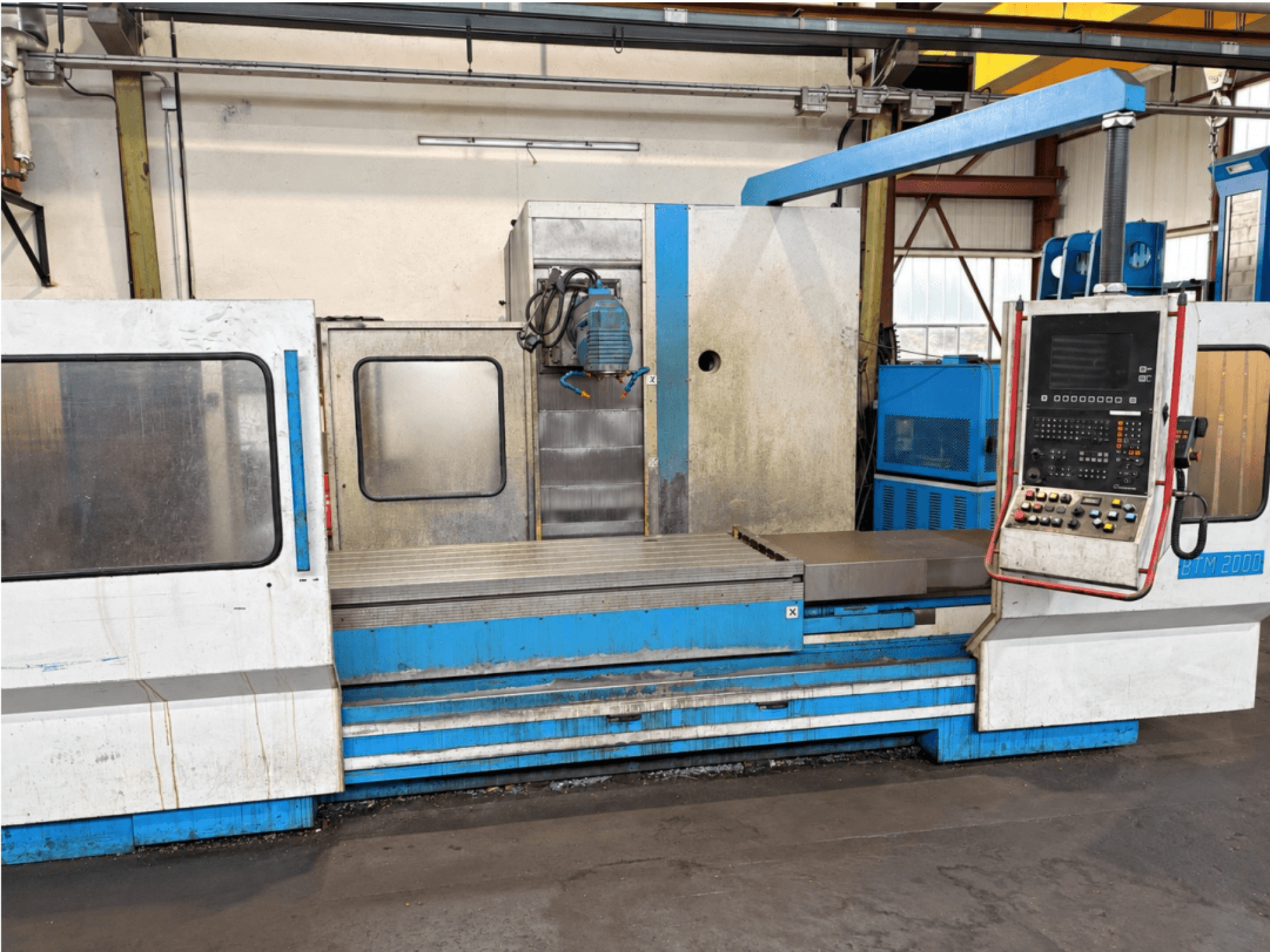 Die Flachschleifmaschine MIKRON BTM 2000 in Frontansicht, mit Blick auf das Bedienfeld und den Schleiftisch.