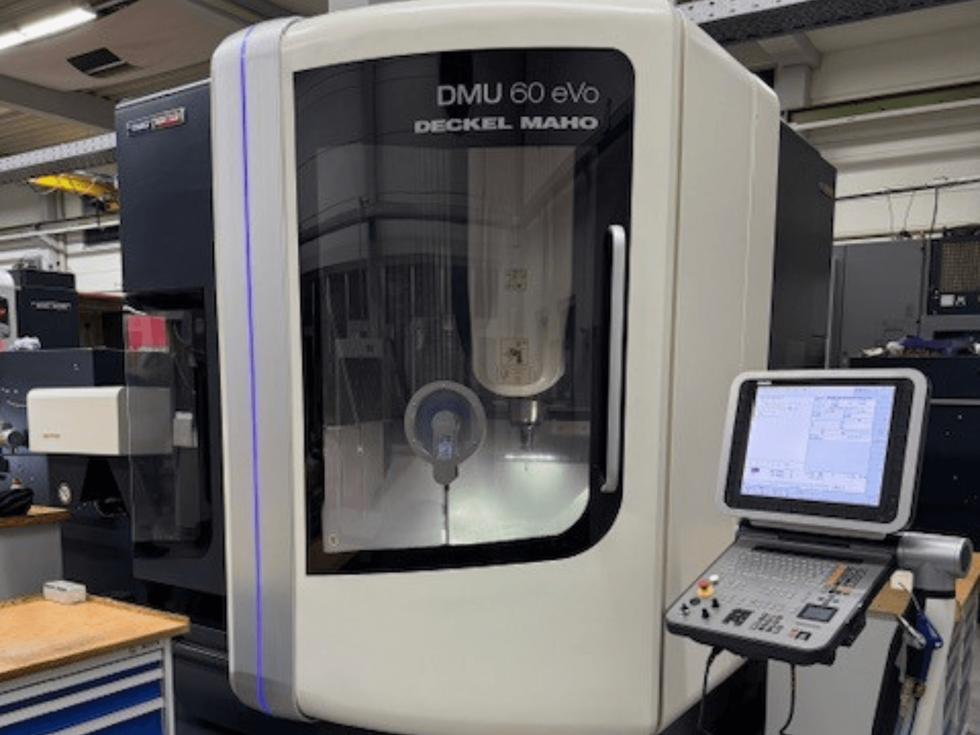 DMU 60 eVo von DECKEL MAHO, Frontansicht der CNC-Fräsmaschine mit Bedienpult und Bildschirm, mit Präzisionskomponenten.