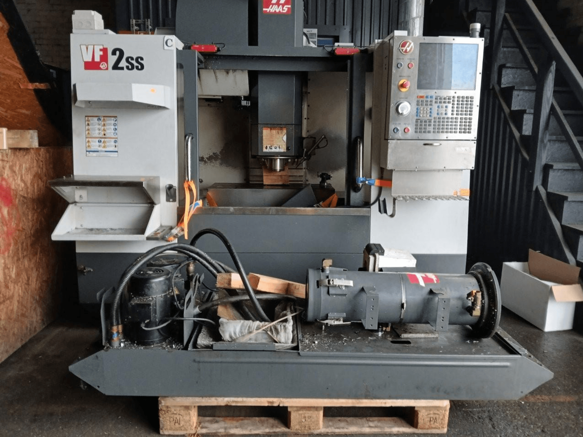 Vertikal-Bearbeitungszentrum HAAS VF-2SS in der Frontansicht mit Bedienfeld, Spindelbereich und angeschlossenen Motorkomponenten.