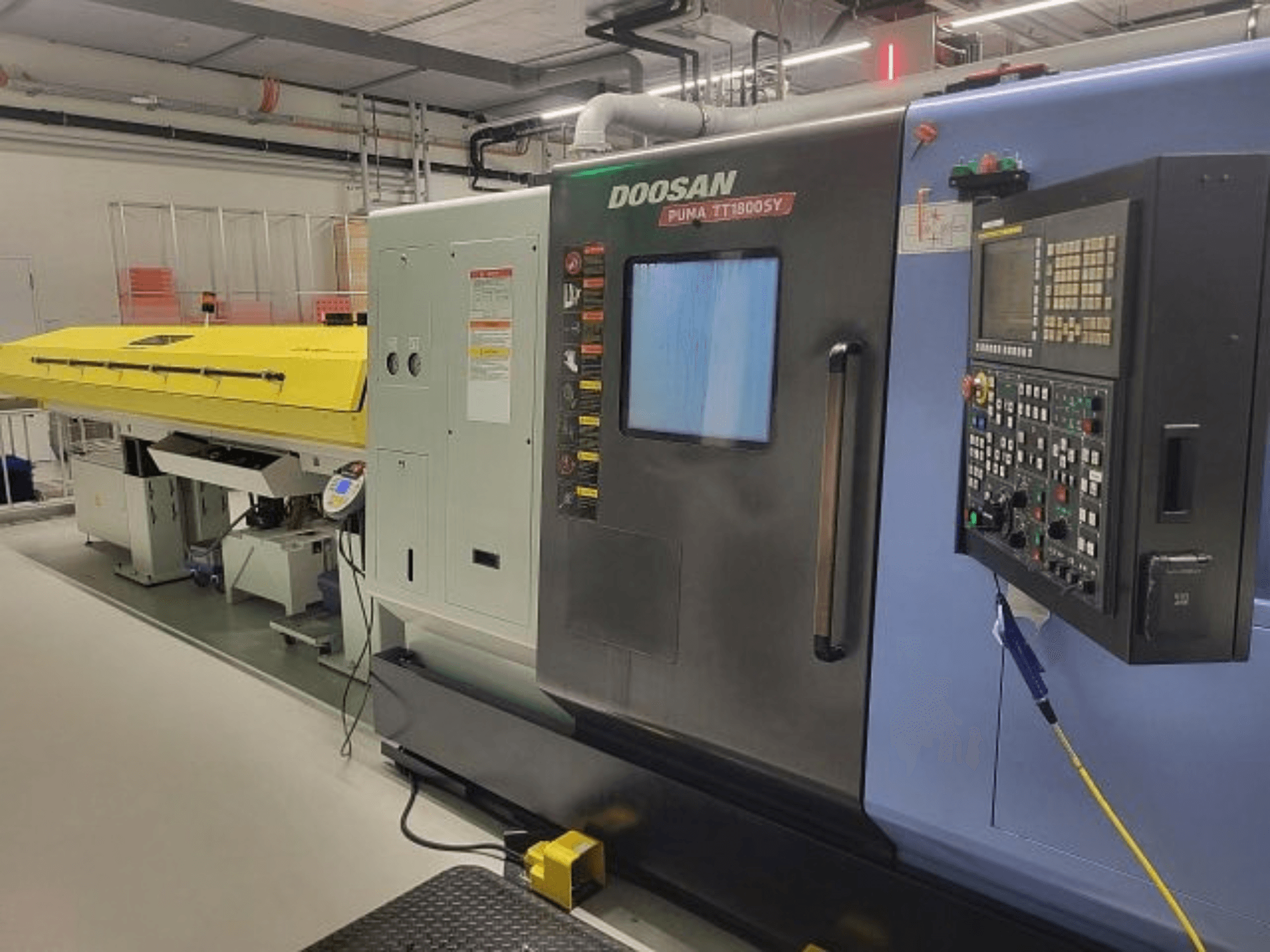 DOOSAN PUMA TT 1800 SY Dreh-Fräszentrum, Vorderansicht mit Bedienfeld und gelber Abdeckung, industrielle Umgebung.