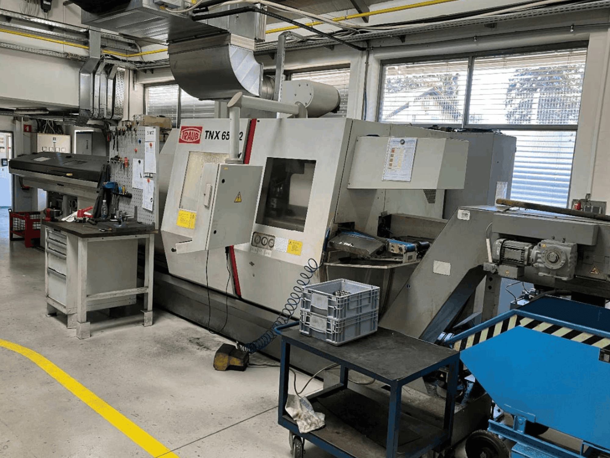 TRAUB TNX 65/42 Dreh-Fräszentrum in einer Werkstatt, Vorderansicht mit Blick auf das Bedienpult und den Arbeitsbereich.