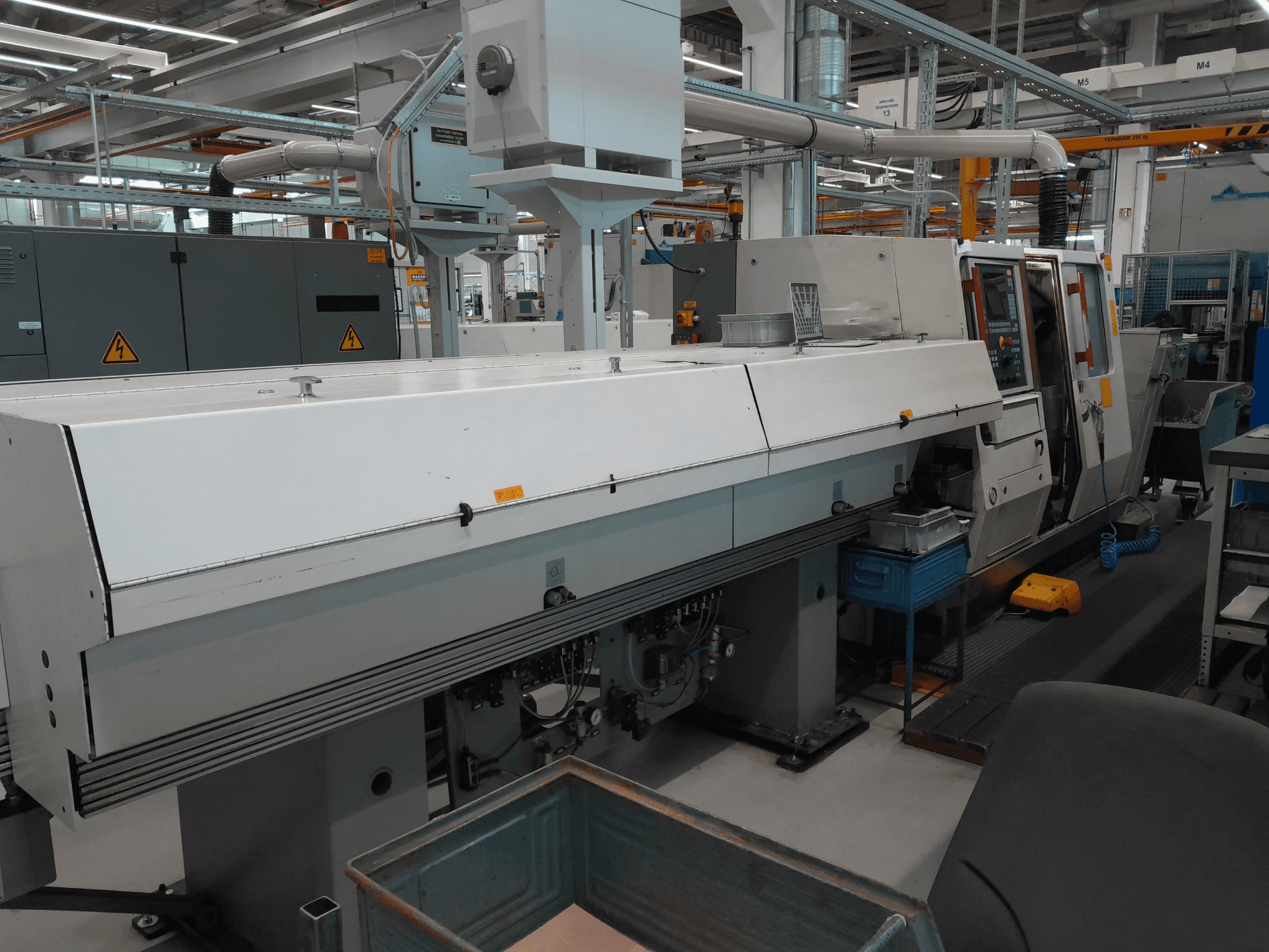 TRAUB TNA 300 Horizontal-Drehmaschine, Vorderansicht; zeichnet sich durch ein schlankes Design, ein Bedienfeld und einen Arbeitsbereich aus.