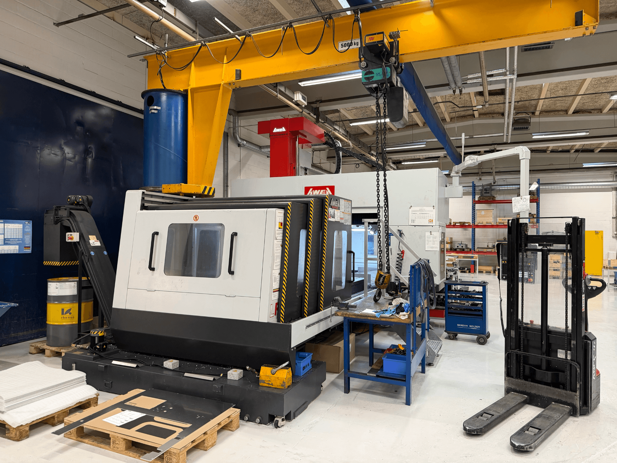 Portalfräsmaschine AWEA LP3016YF, Vorderansicht, mit Werkzeugen, blauem Tank und Arbeitsbereich im Hintergrund.