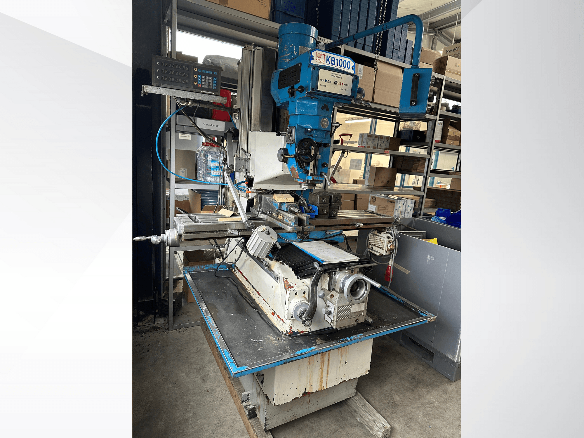 Vertikalfräsmaschine KB1000 mit Digitalanzeige, Seitenansicht mit Tisch, Spindel und Werkzeughalter.