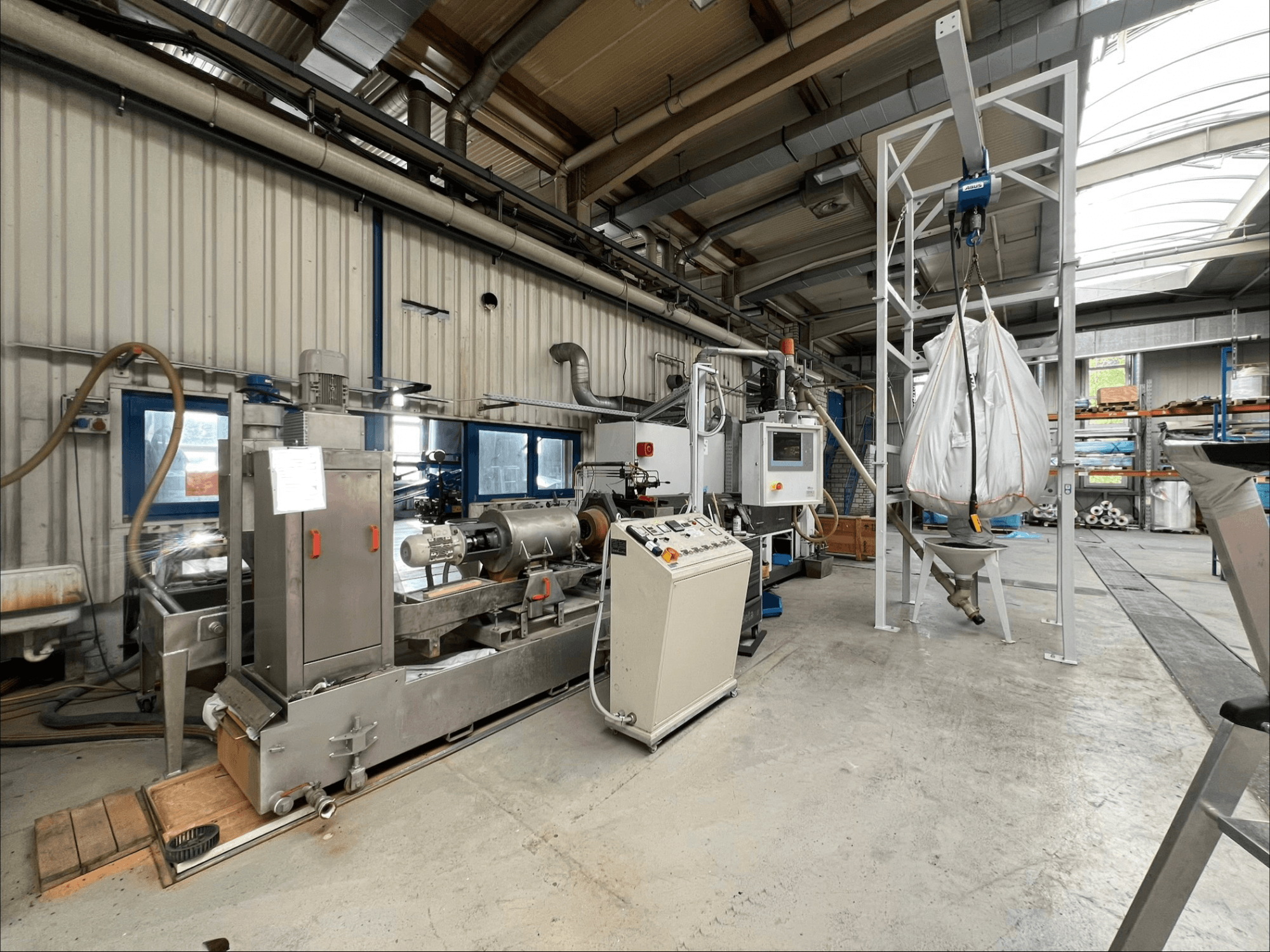 Vorderansicht der Kunststoffverarbeitungsmaschine FILTEC GRP 350 in einer industriellen Umgebung, mit Bedienelementen und Zuführsystem.