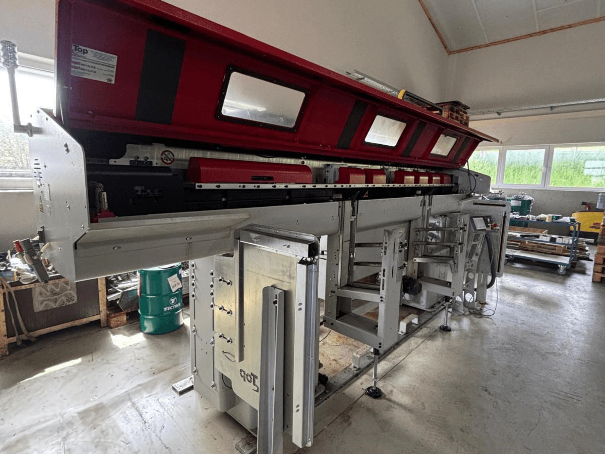 TOP Automazioni Top Loader ETL 10-75, von der Seite gesehen, mit rotem Oberteil und komplexen Maschinenkomponenten.