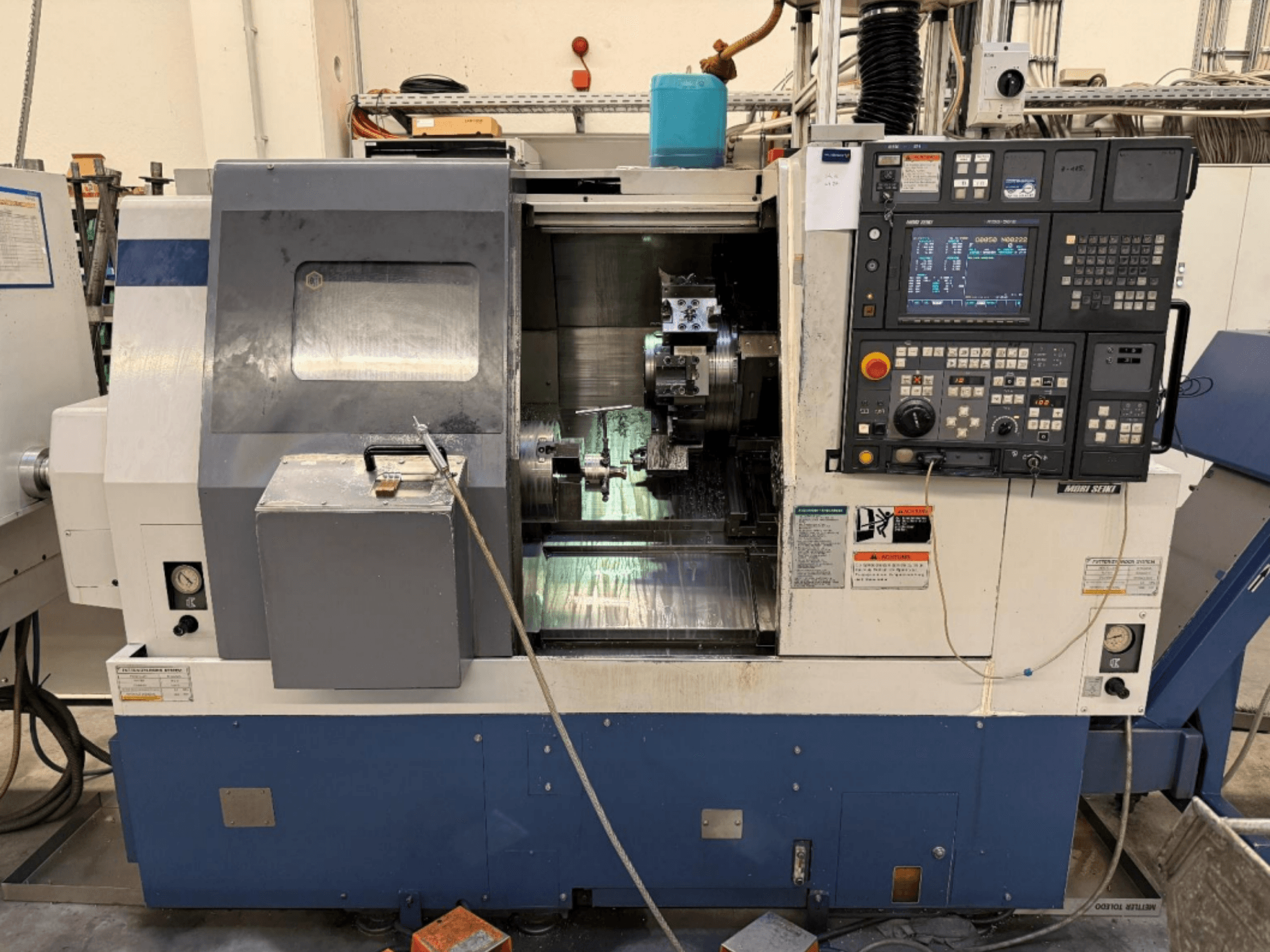 MORI SEIKI SL-250ASMC Dreh-Fräszentrum, Vorderansicht mit Bedienfeld und Werkstückspannfutter im Betrieb.