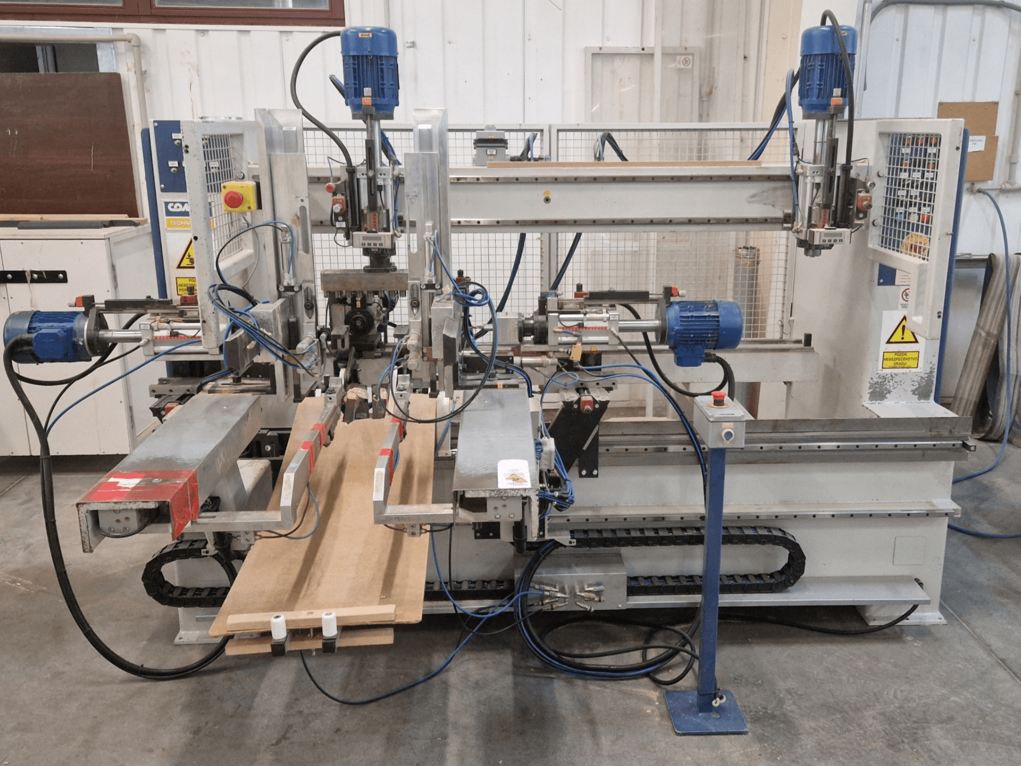 COMEC FMOV 1500 Mehrspindelbohrmaschine, Vorderansicht, zeigt Doppelspindeln, Bedienfeld und Holzstück in Betrieb.