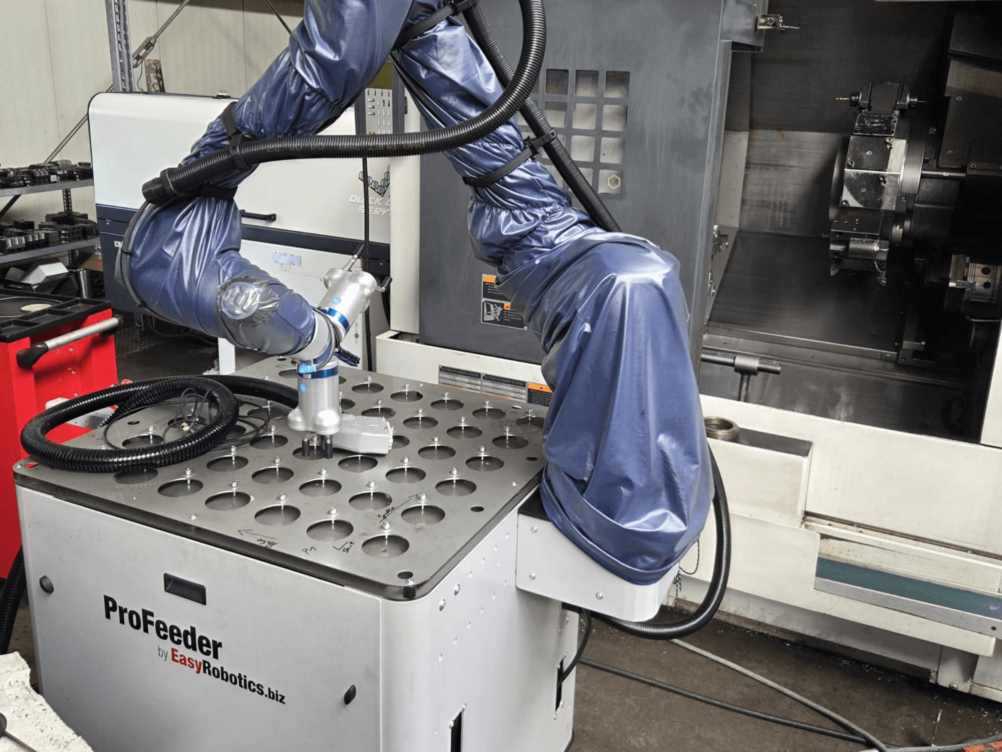 Kollaborationsroboter EASYROBOTICS ProFeeder in der Frontansicht, mit einem Roboterarm, der über einem perforierten Metalltisch positioniert ist.