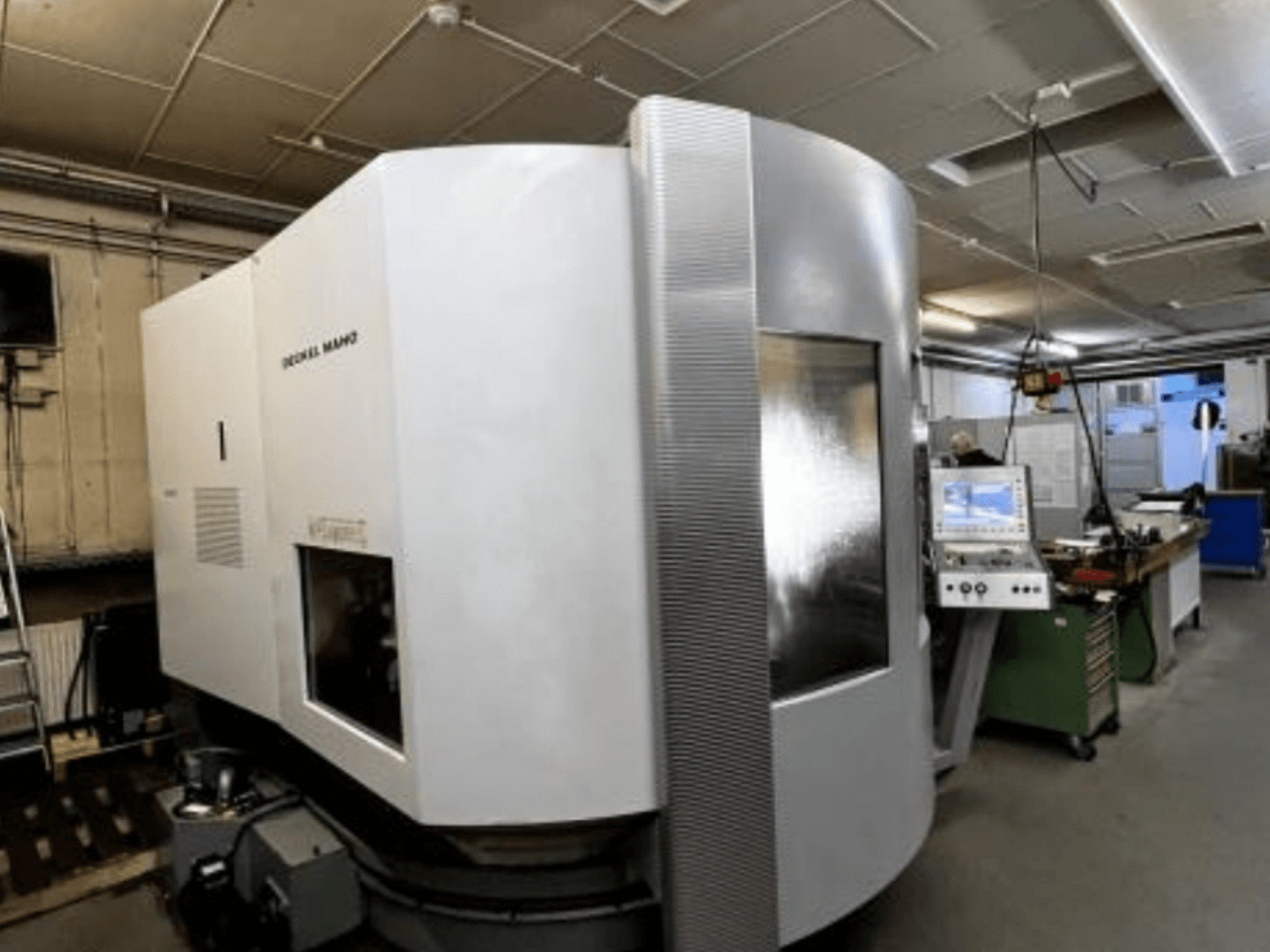 SODICK MAKO CNC-Maschine in einer Werkstatt, Seitenansicht, mit Bedienfeld und Arbeitsbereich im Hintergrund.