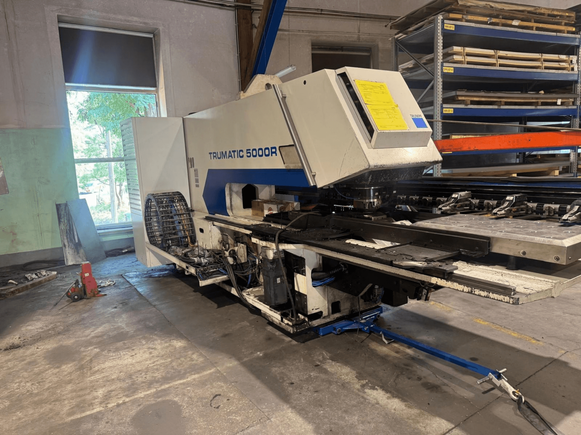 CNC-Stanzmaschine TRUMPF TRUMATIC 5000R in einer Werkstatt, Vorderansicht mit Blick auf die Bedienelemente und den Stanzbereich.