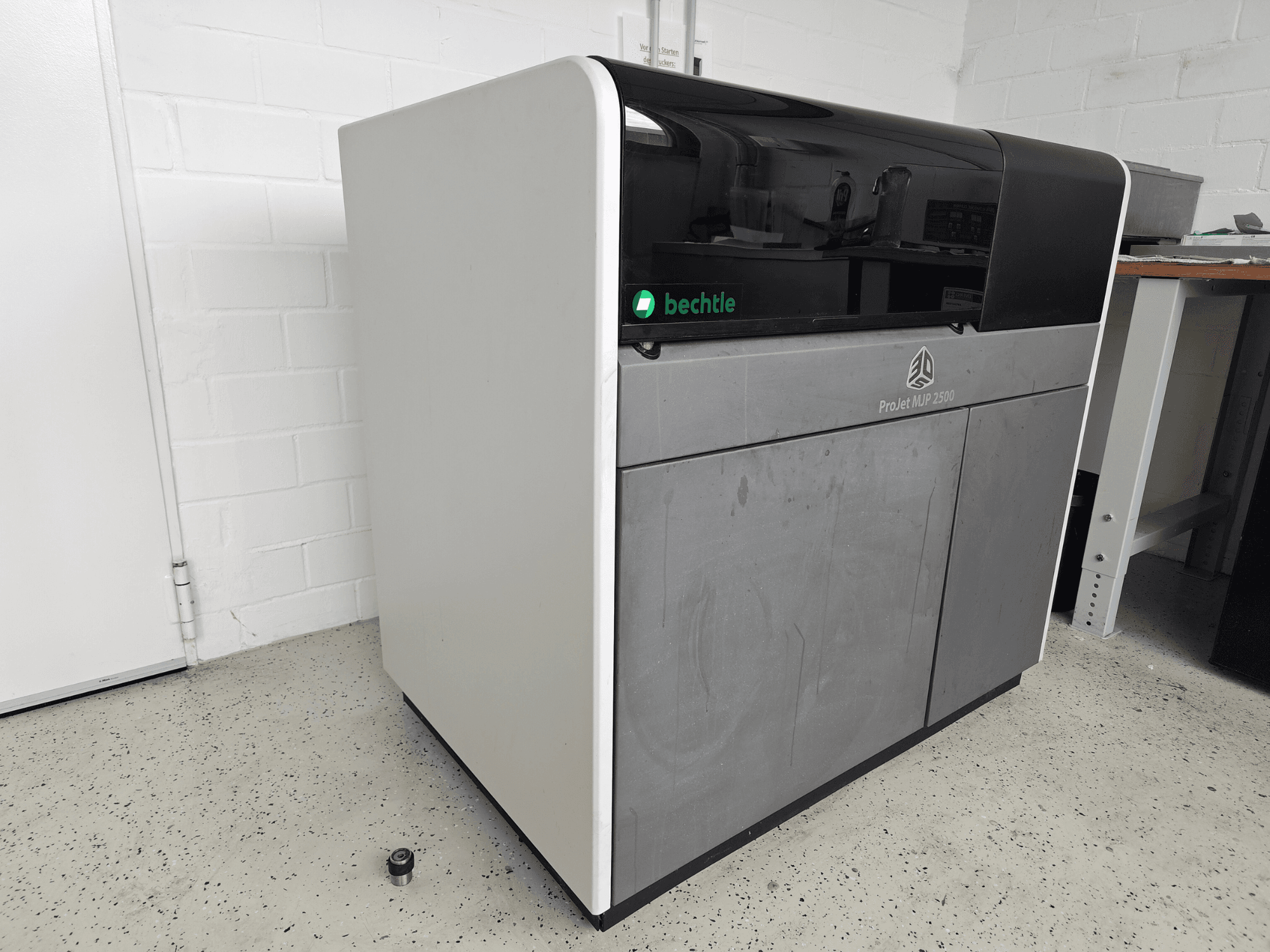 Der 3D-Drucker „ProJet MJP 2500 Plus“ von 3D Systems in der Vorderansicht; er zeichnet sich durch ein schlankes Design mit dunkler Oberseite und hellem Gehäuse aus.