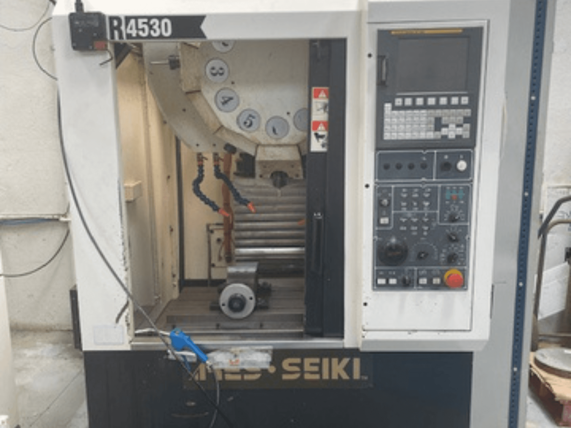 Vertikales Bearbeitungszentrum ARES-SEIKI R4530, Frontansicht mit Bedienfeld und Arbeitsbereich mit Spindel und Kühlmittelanlage.