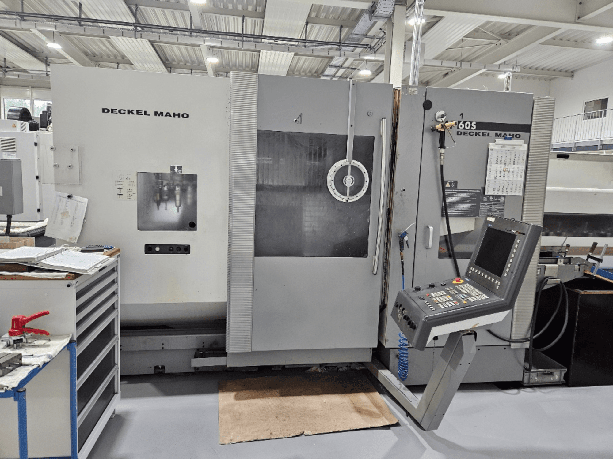 Deckel Maho 605 CNC-Maschine mit Bedienpult und Bedienelementen, von vorne gesehen in einer Werkstattumgebung.