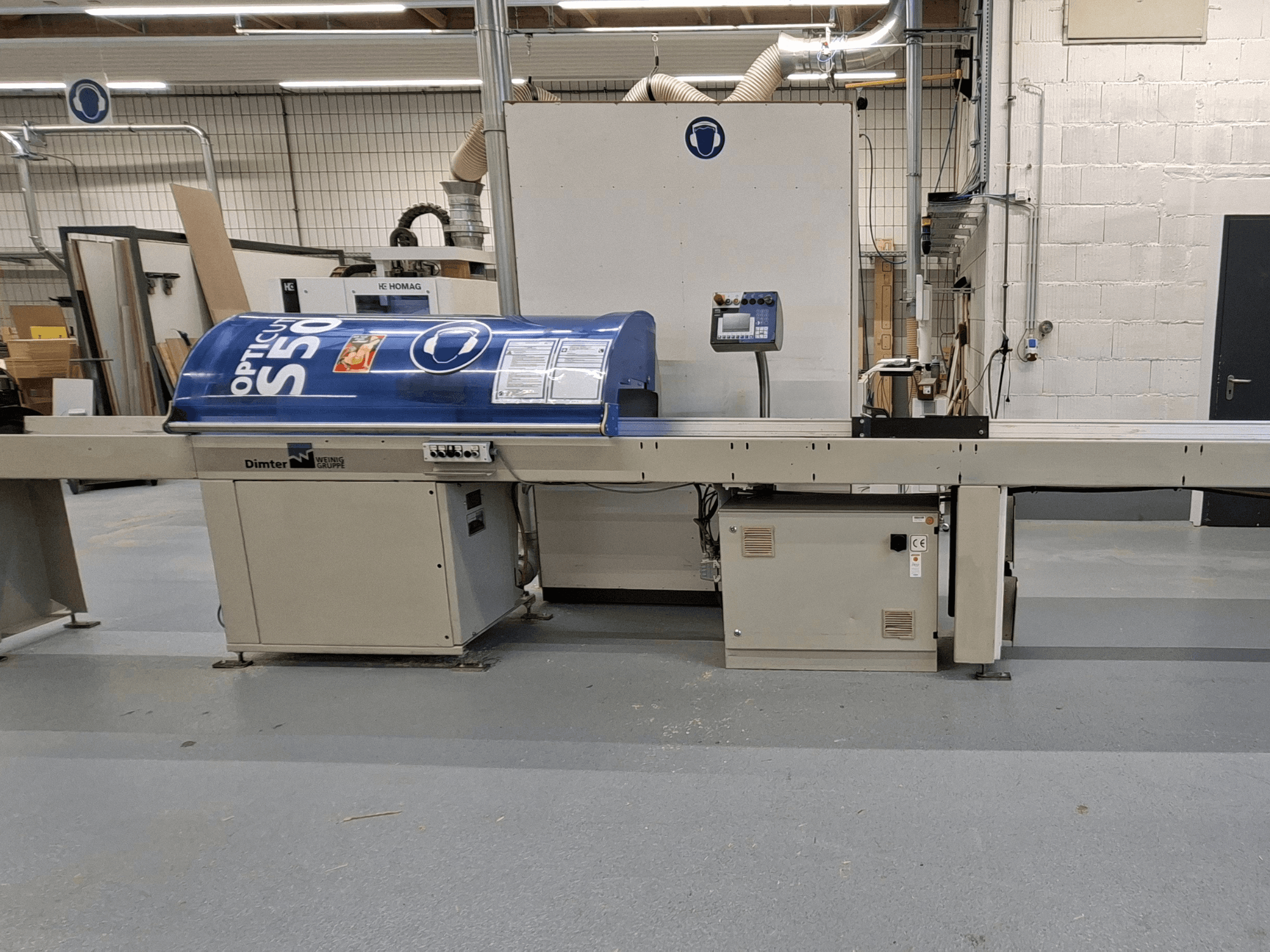 Dimter OptiCut S50 Holzschneidemaschine in der Seitenansicht, mit blauem Gehäuse, Bedienfeld und Förderband.