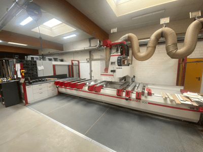 CNC-Maschine BIMA 400 von vorne gesehen, mit rot-weißem Design und Staubabsaugung.