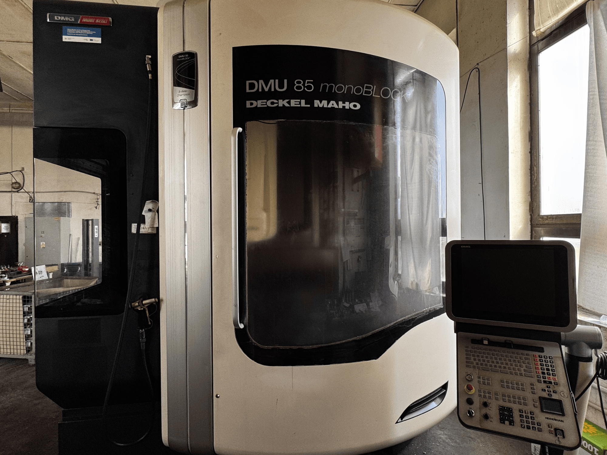 DMG MORI DMU 85 monoBLOCK Vertikal-Bearbeitungszentrum, Frontansicht mit Bedienfeld und großem Sichtfenster.
