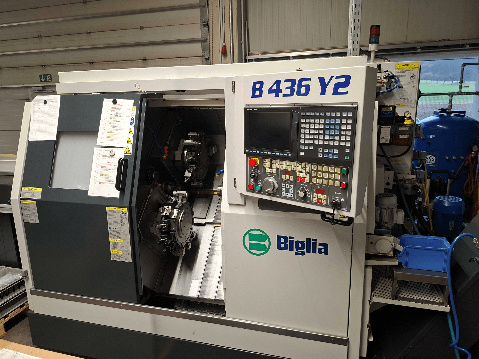Biglia B 436 Y2 CNC-Drehmaschine in der Seitenansicht, mit zwei Spindeln und Bedienfeld mit Tasten und Display für die Bedienung.