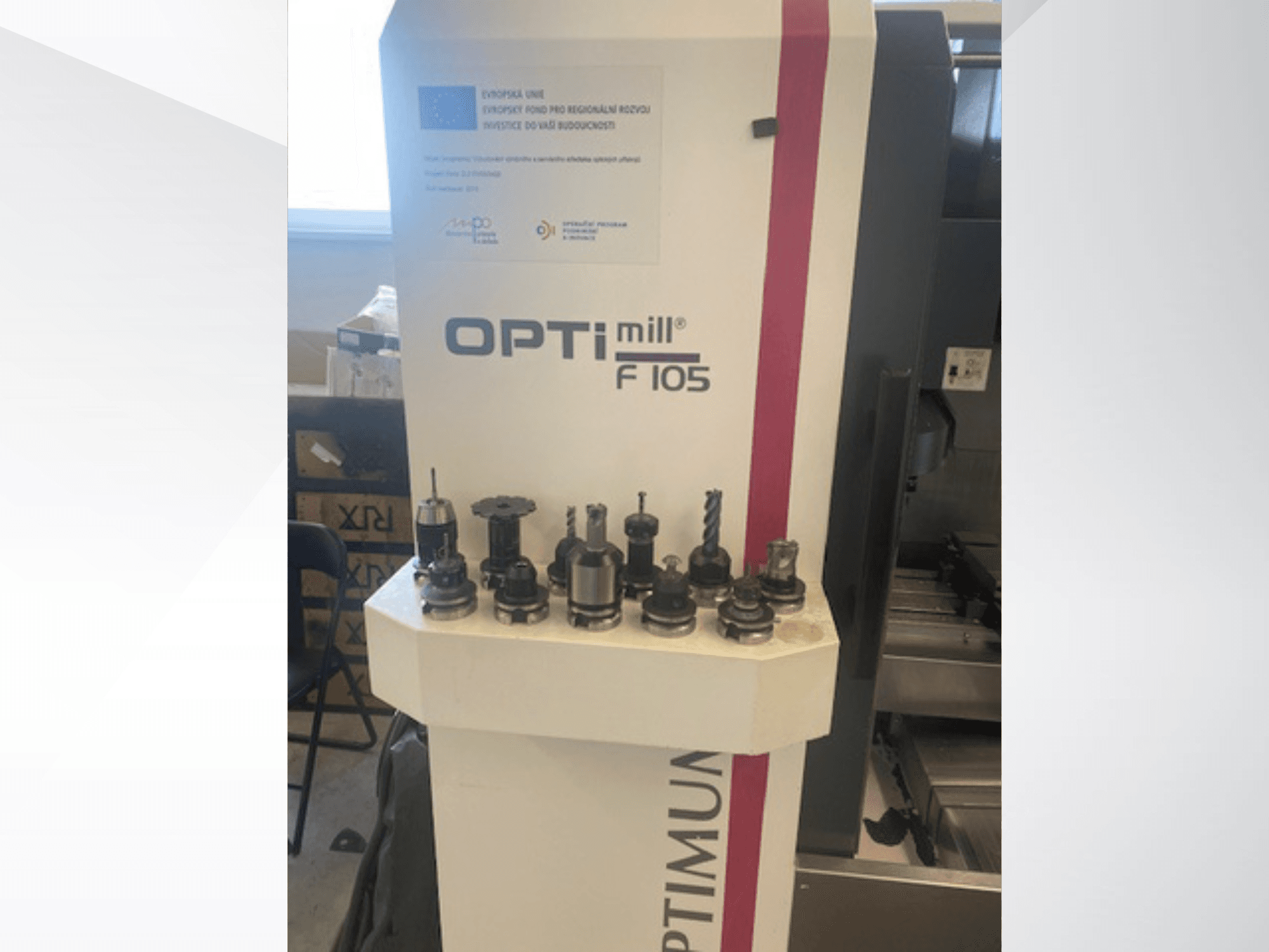 Vorderansicht des vertikalen Bearbeitungszentrums „Optimum Optimill F105“ mit verschiedenen seitlich angebrachten Werkzeugen.