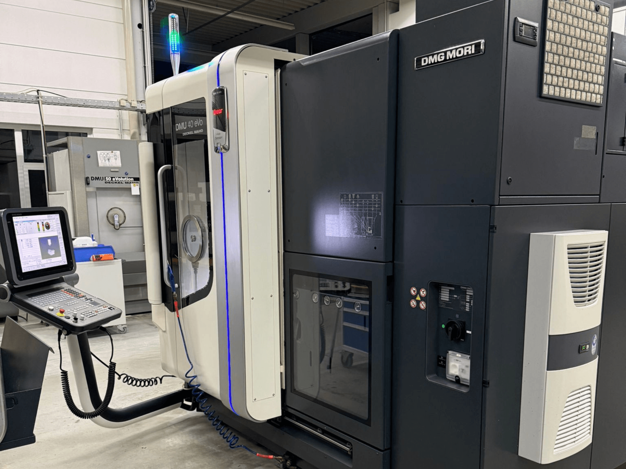 DMG MORI DMU 40 eVo Maschine, Frontansicht mit Bedienelementen, LED-Anzeigen und schlankem Design, das die industriellen Merkmale betont.