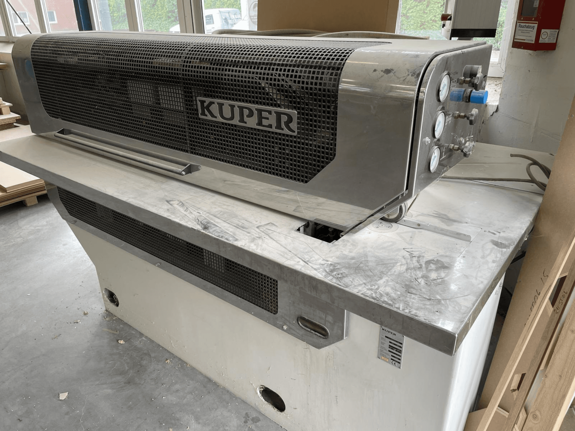 Furnierschere KUPER FLI, Vorderansicht, mit einem Gehäuse aus Edelstahl, Lehren und einem sauberen Schneidbereich auf einer Werkbank.