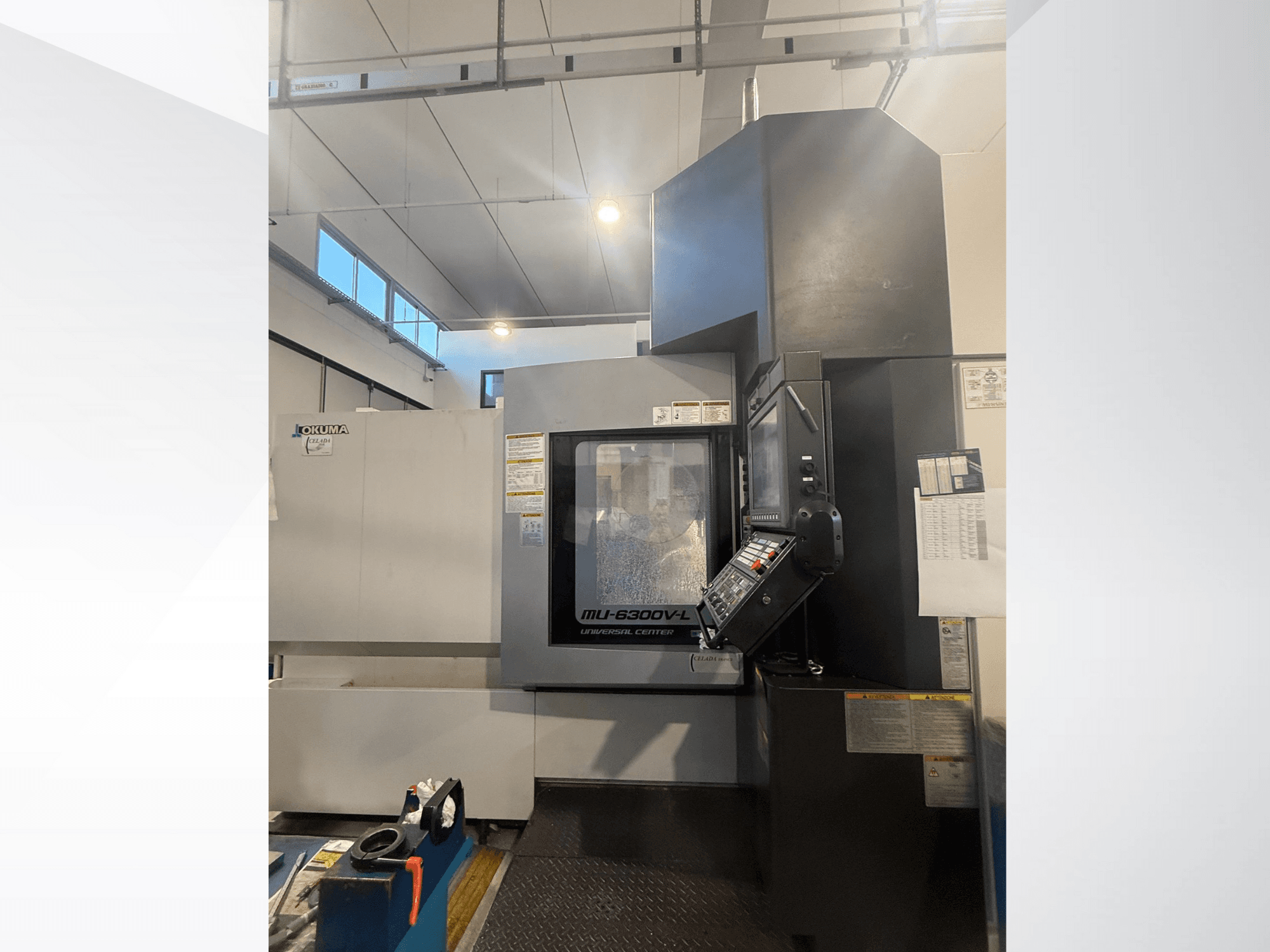 Okuma MU-6300V-L CNC-Maschine von vorne gesehen, mit Bedienfeld und Sicherheitsschildern.