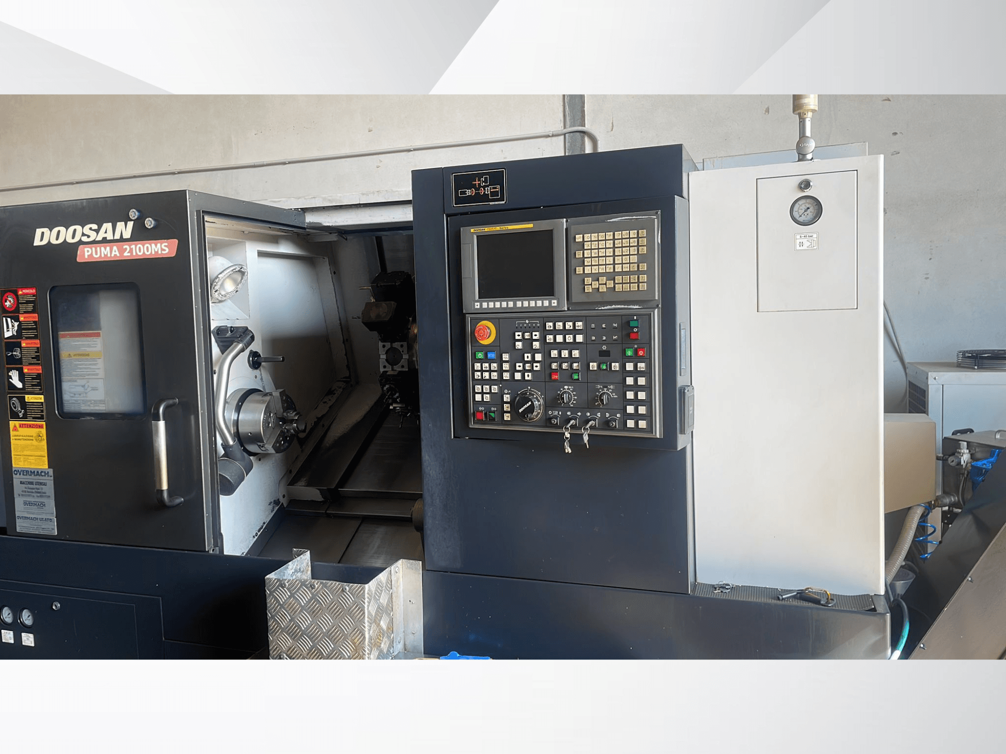 Vorderansicht der Horizontal-Drehmaschine DOOSAN PUMA 2100MS mit Blick auf das Bedienfeld, die Spindel und die Schneidwerkzeuge im Inneren der Kammer.