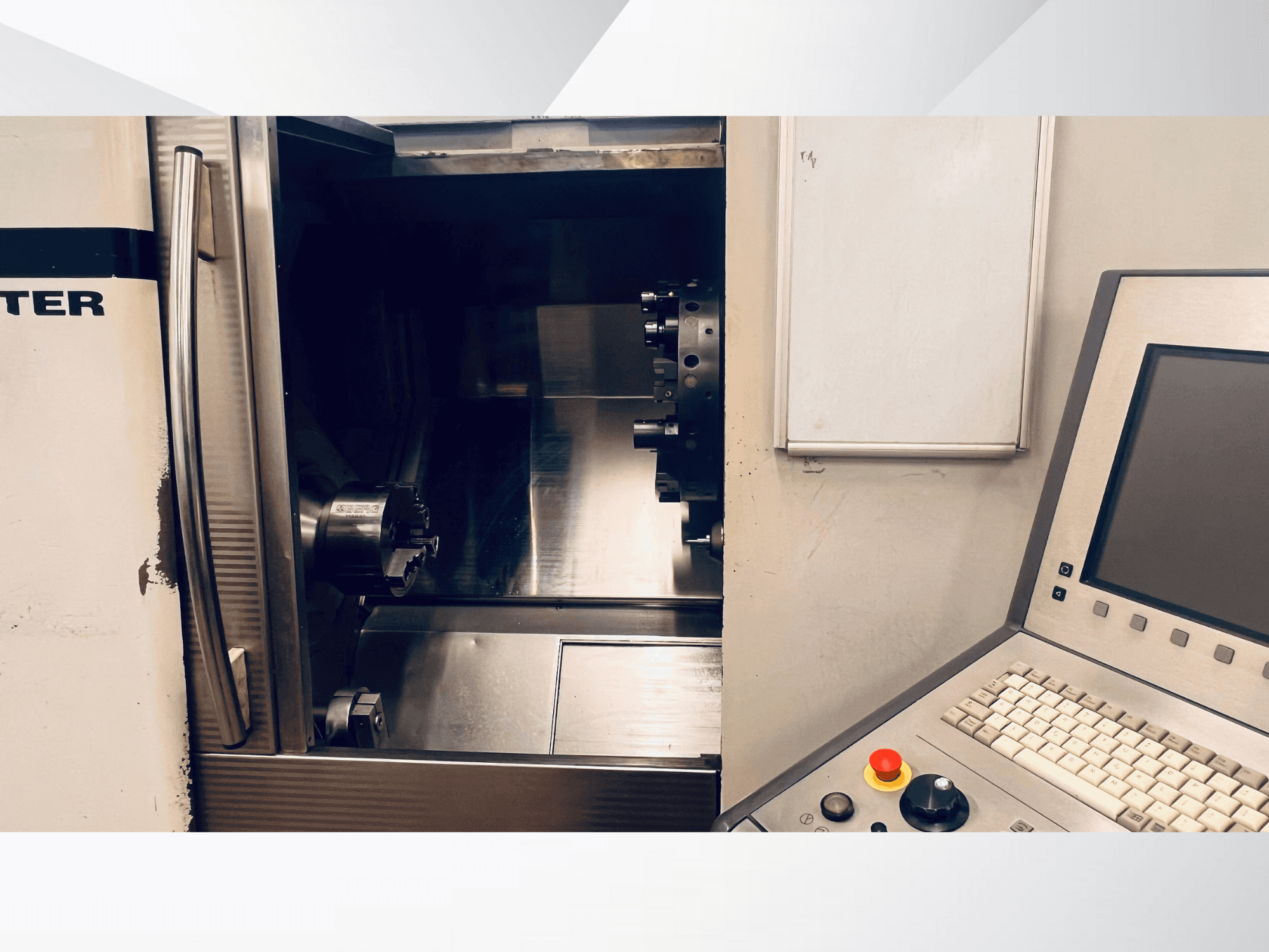 Die Vorderansicht der CNC-Maschine zeigt die offene Kammer und das Bedienfeld mit der Tastatur und der Not-Aus-Taste.