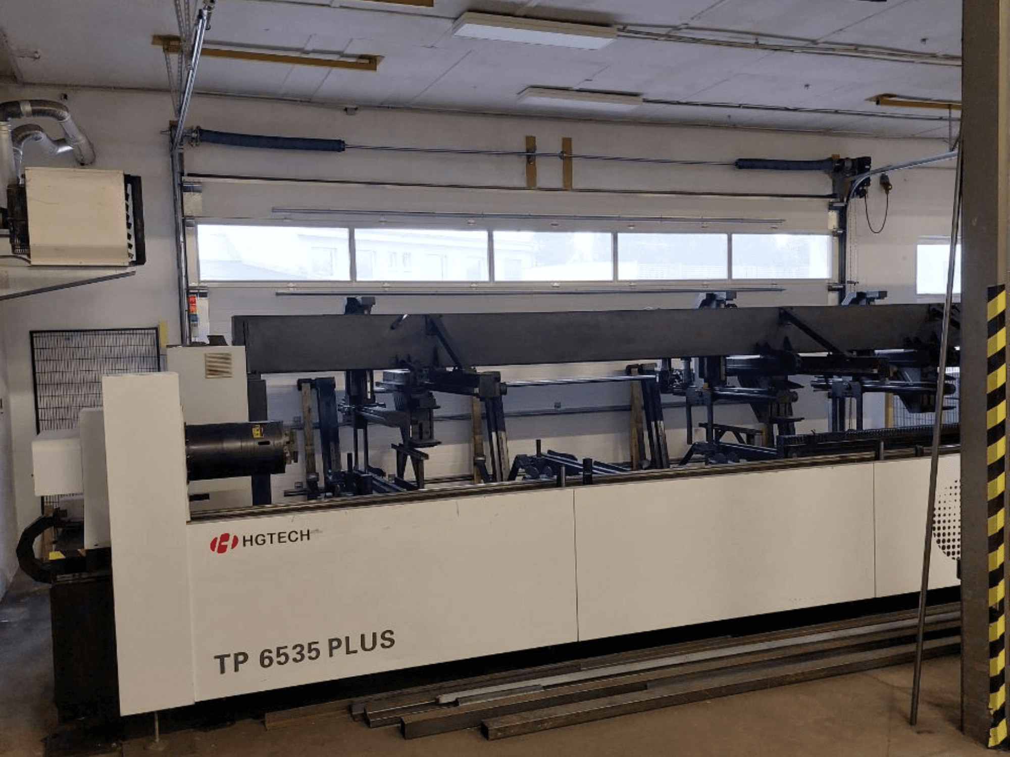 HGTECH TP 6535 PLUS, Vorderansicht einer großen Industriemaschine mit mehreren Armen für die Präzisionsfertigung, aufgestellt in einer Werkstatt.